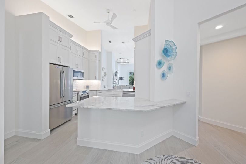 A kitchen with white cabinets and stainless steel appliances.