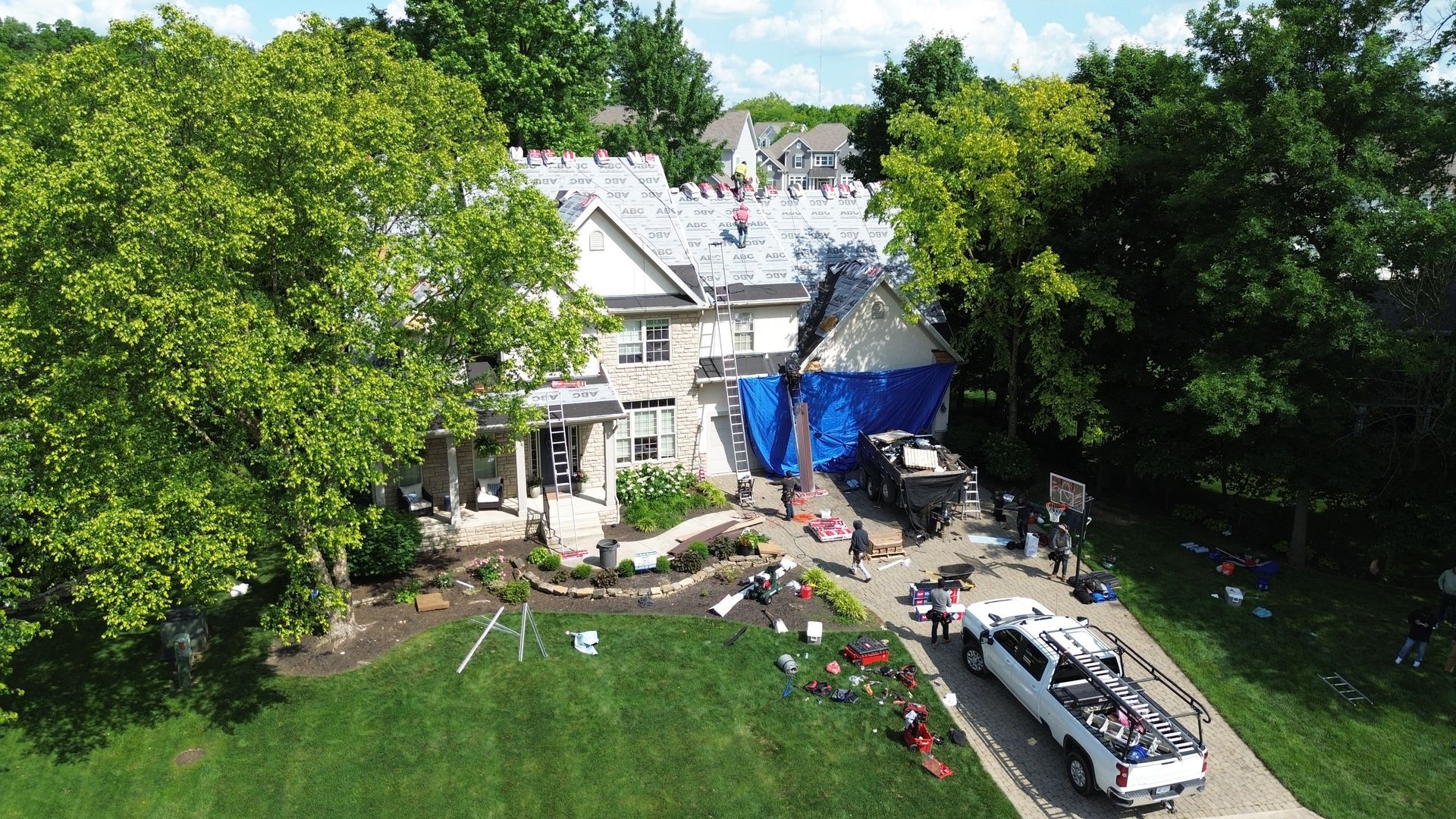 A roof with a lot of shingles and trees in the background.