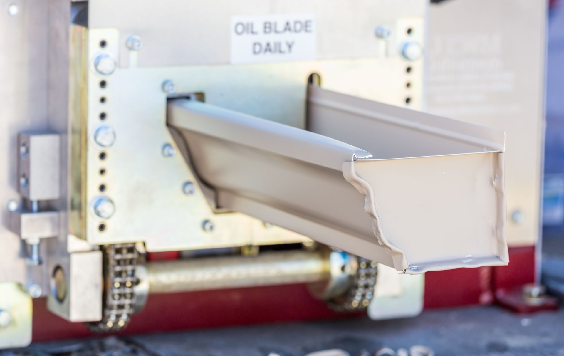 A man is standing on a ladder fixing a gutter on the roof of a house.