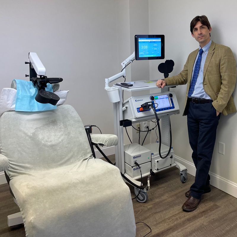 Dr. Jack Castro with a Magventure TMS Therapy chair and device.
