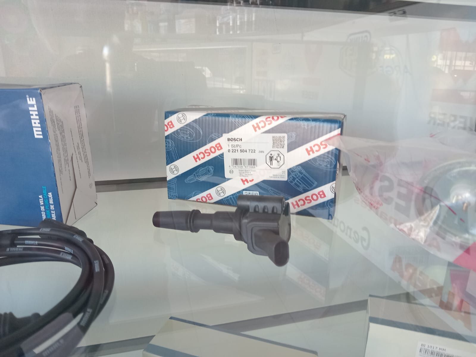 Bobina de encendido junto a una caja Bosch en un taller.