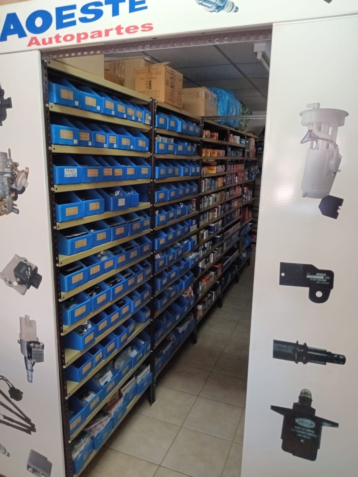 Estantes llenos de contenedores azules en una tienda de autopartes. Letrero