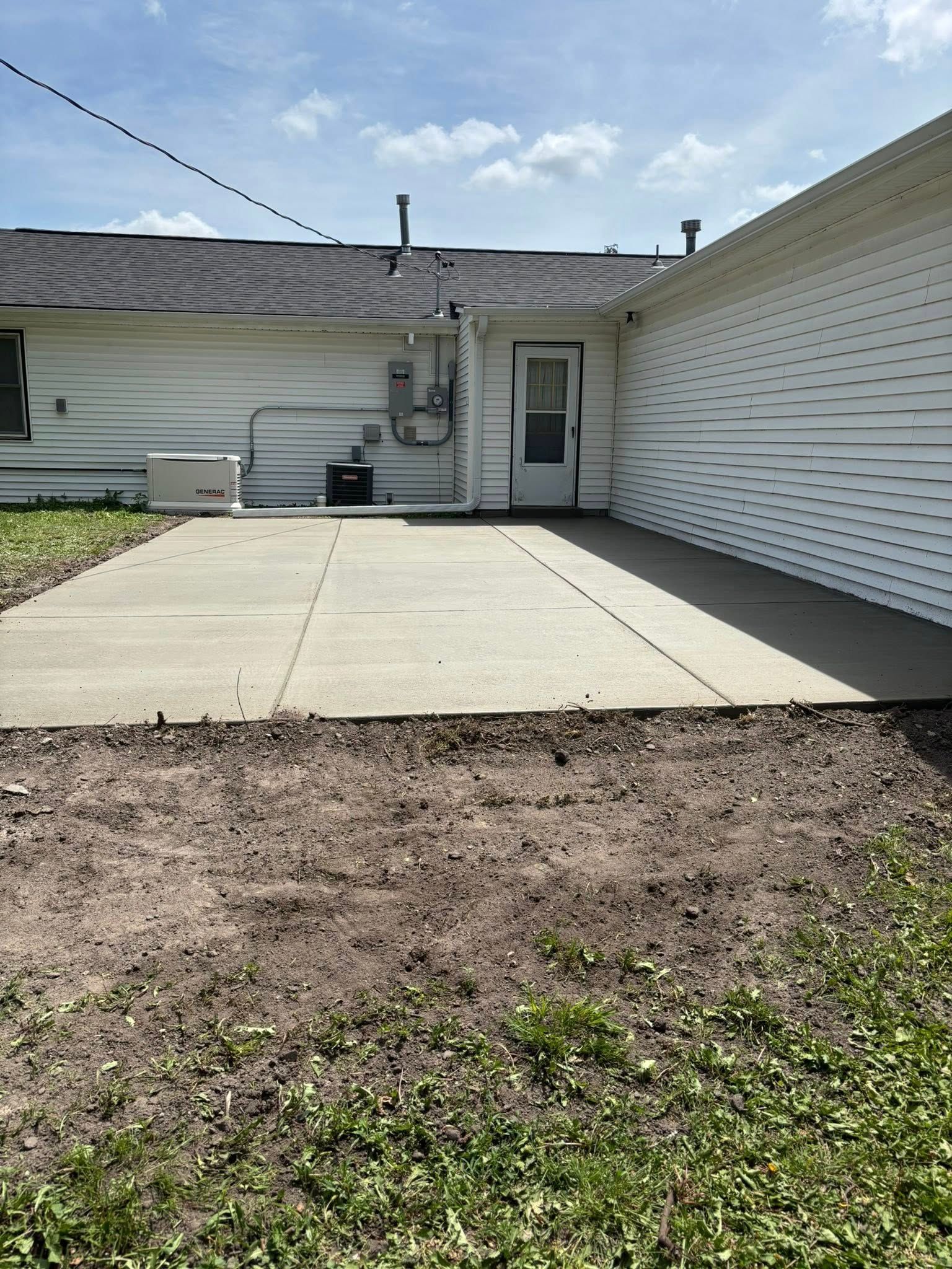 A white house with a concrete driveway in front of it.