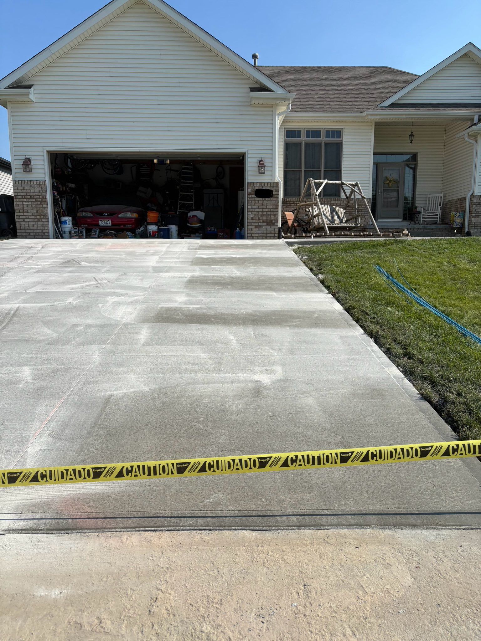 A white house with a concrete driveway in front of it.