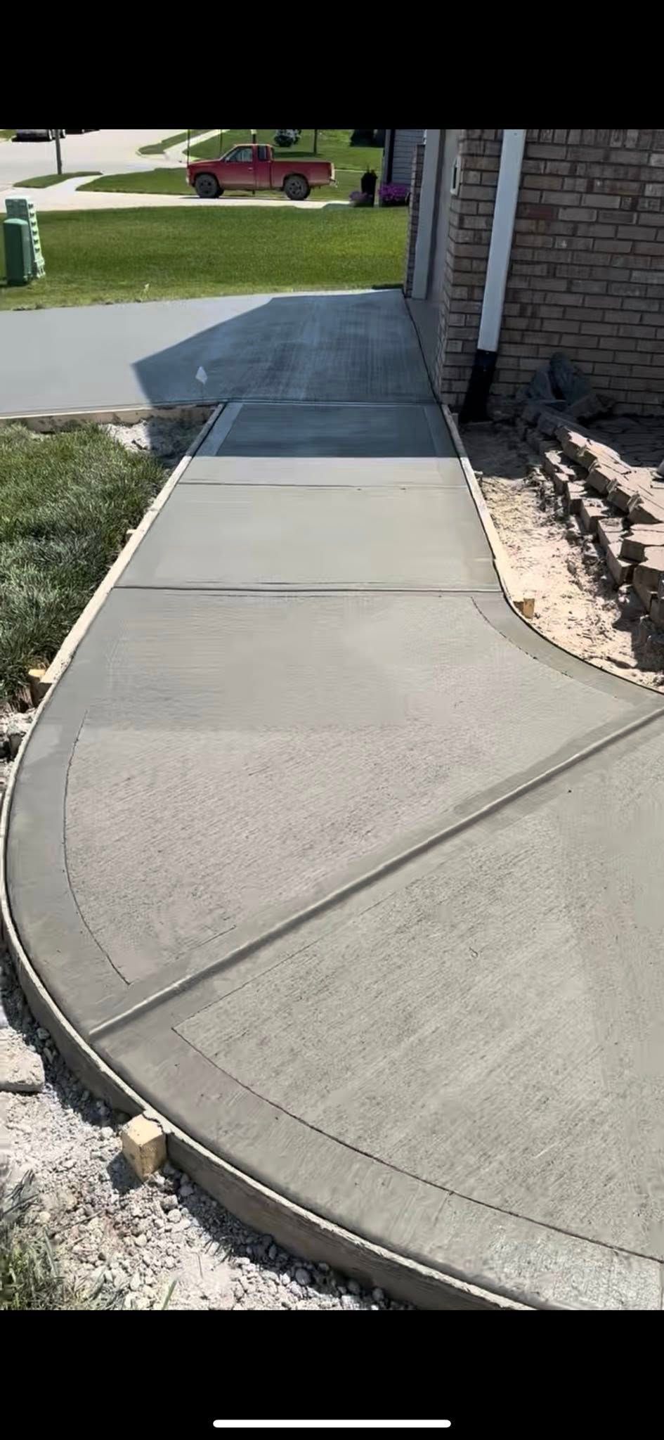 A concrete walkway is being built in front of a house.