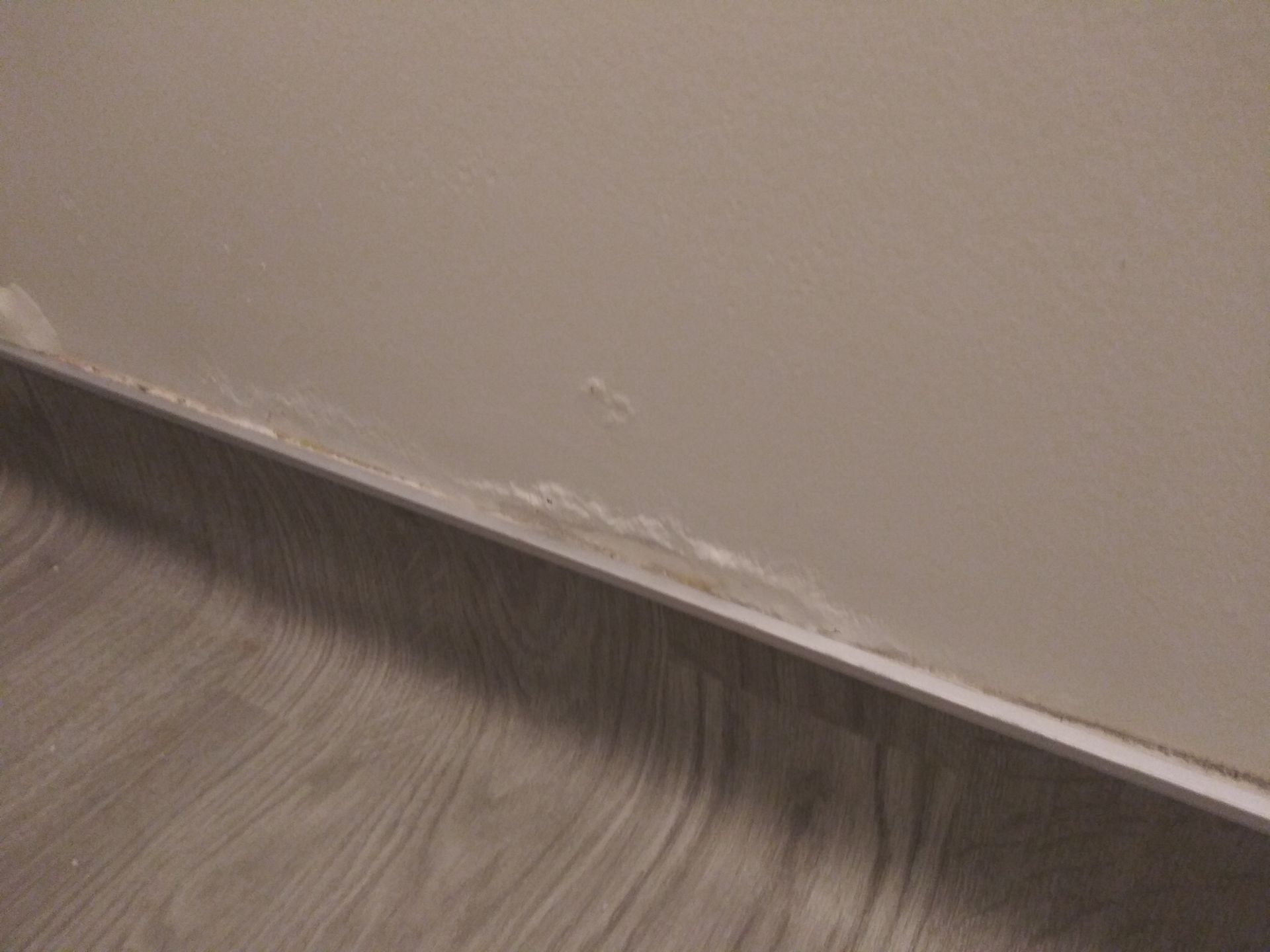 A close up of a wooden floor next to a wall.