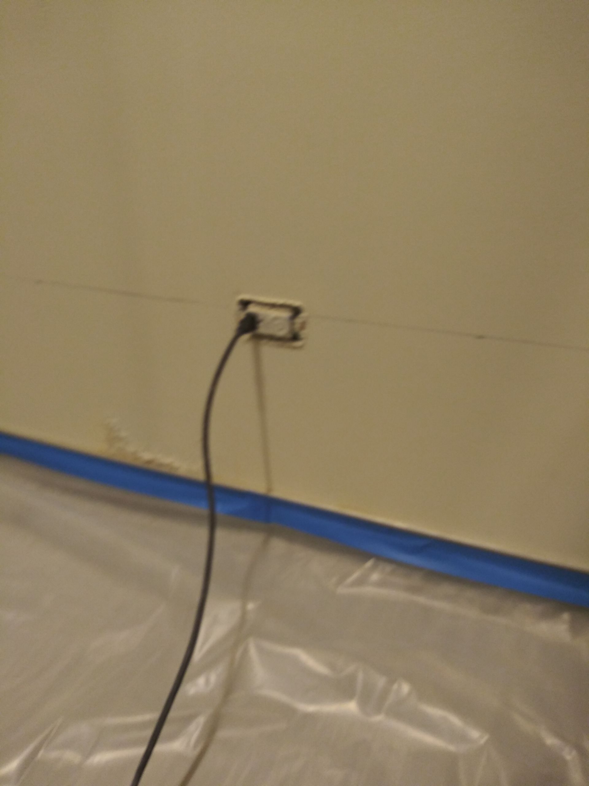A cord is plugged into an outlet on a wall.