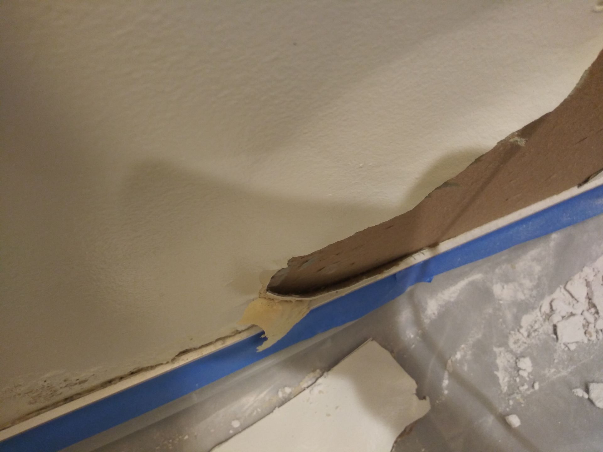 A blue tape is being used to cover a hole in a wall.