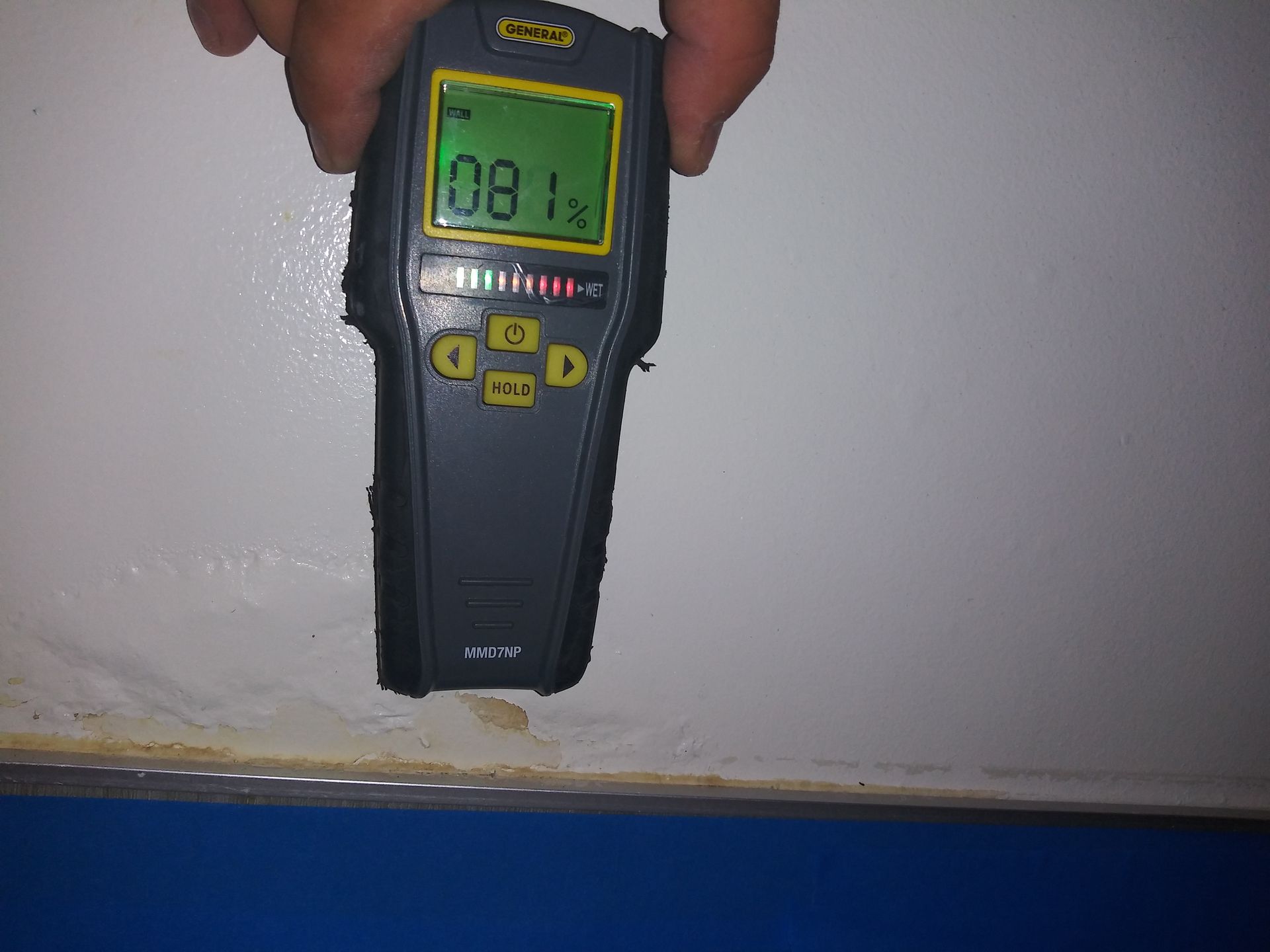 A hand is holding a digital device that says 0.81 on the screen