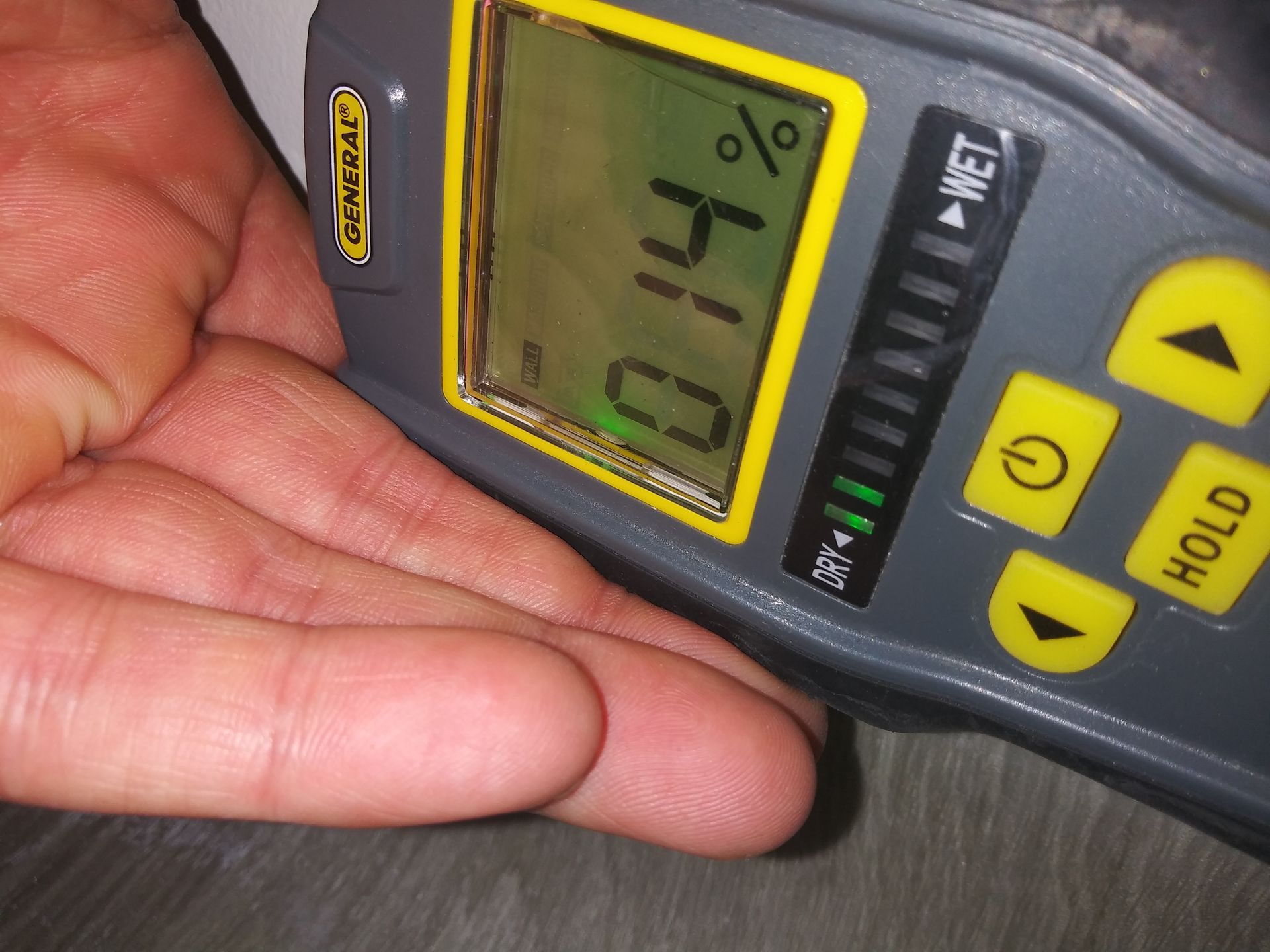 A hand is holding a device that shows a percentage of 44.5