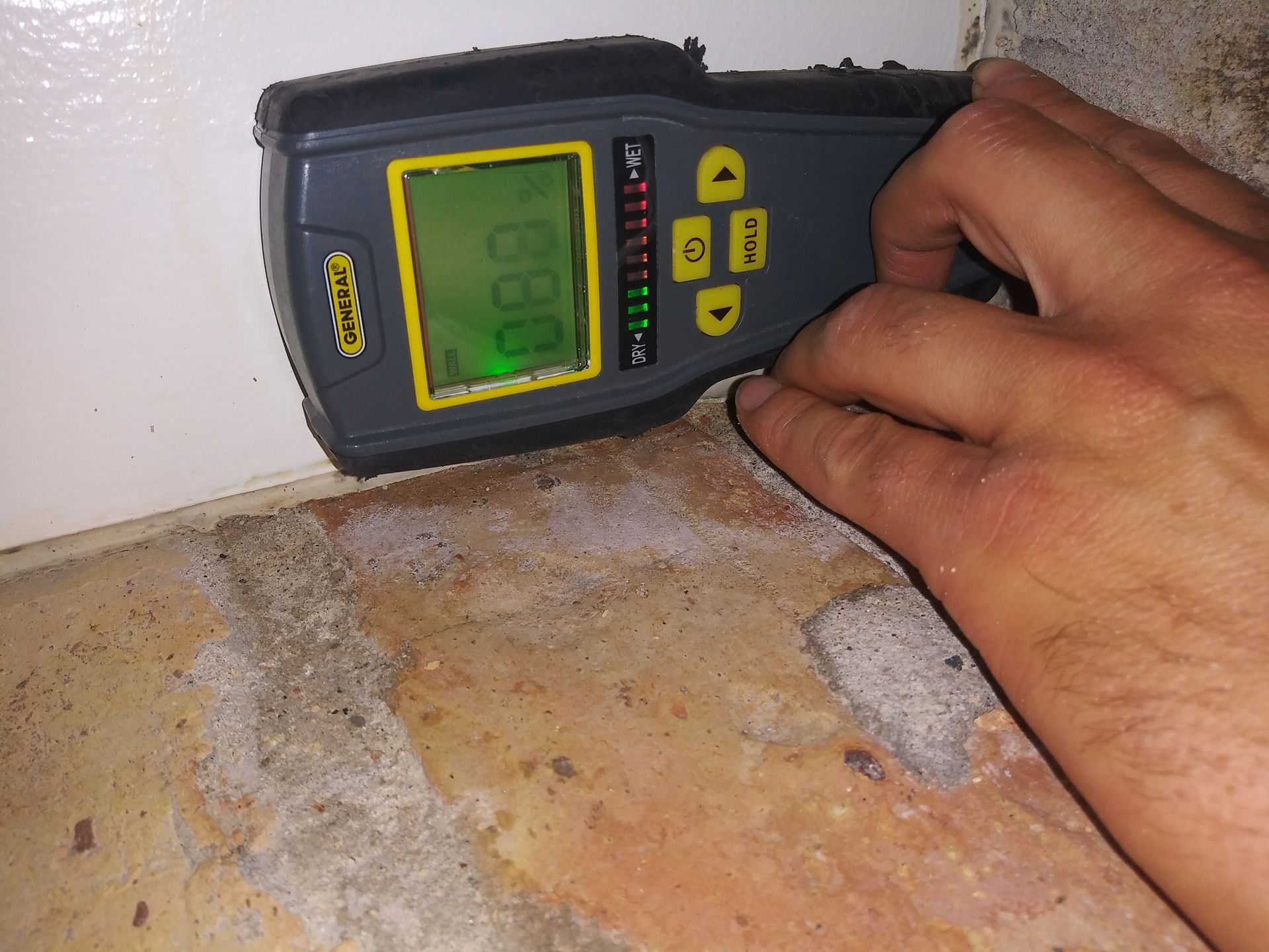 A person is measuring a wall with a device that reads 0.80