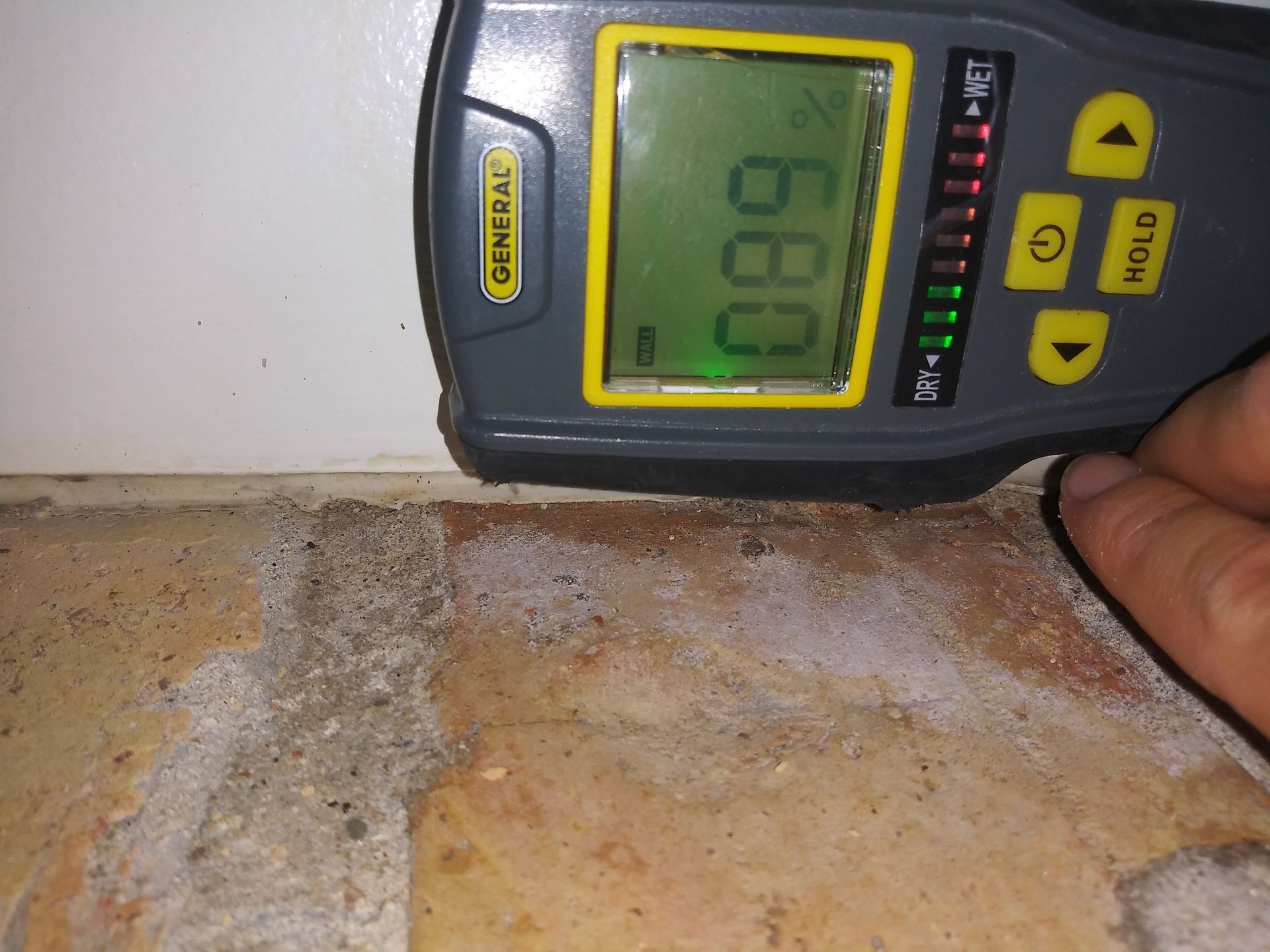 A person is measuring a wall with a general brand device