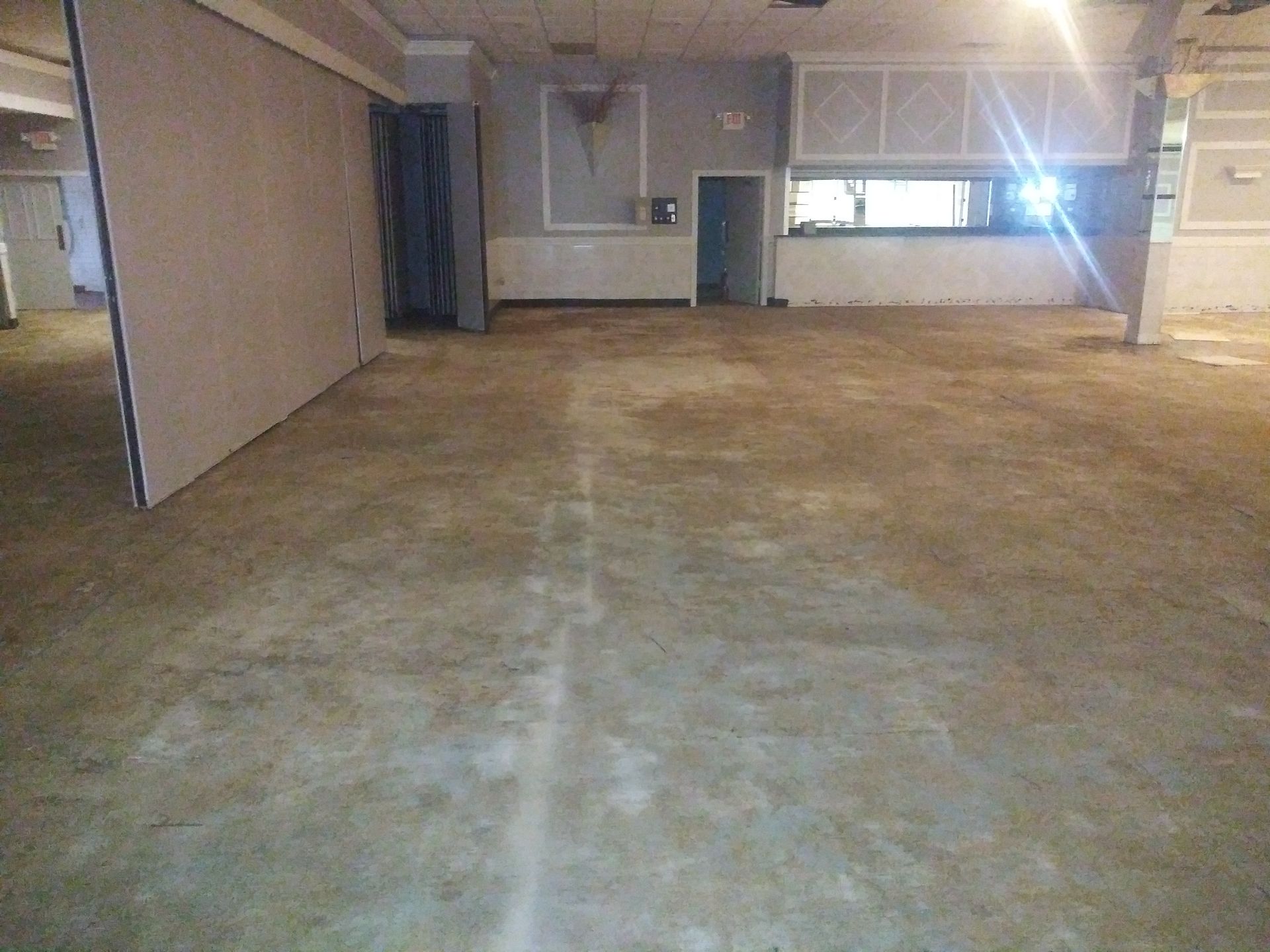 A large empty room with a concrete floor and walls.
