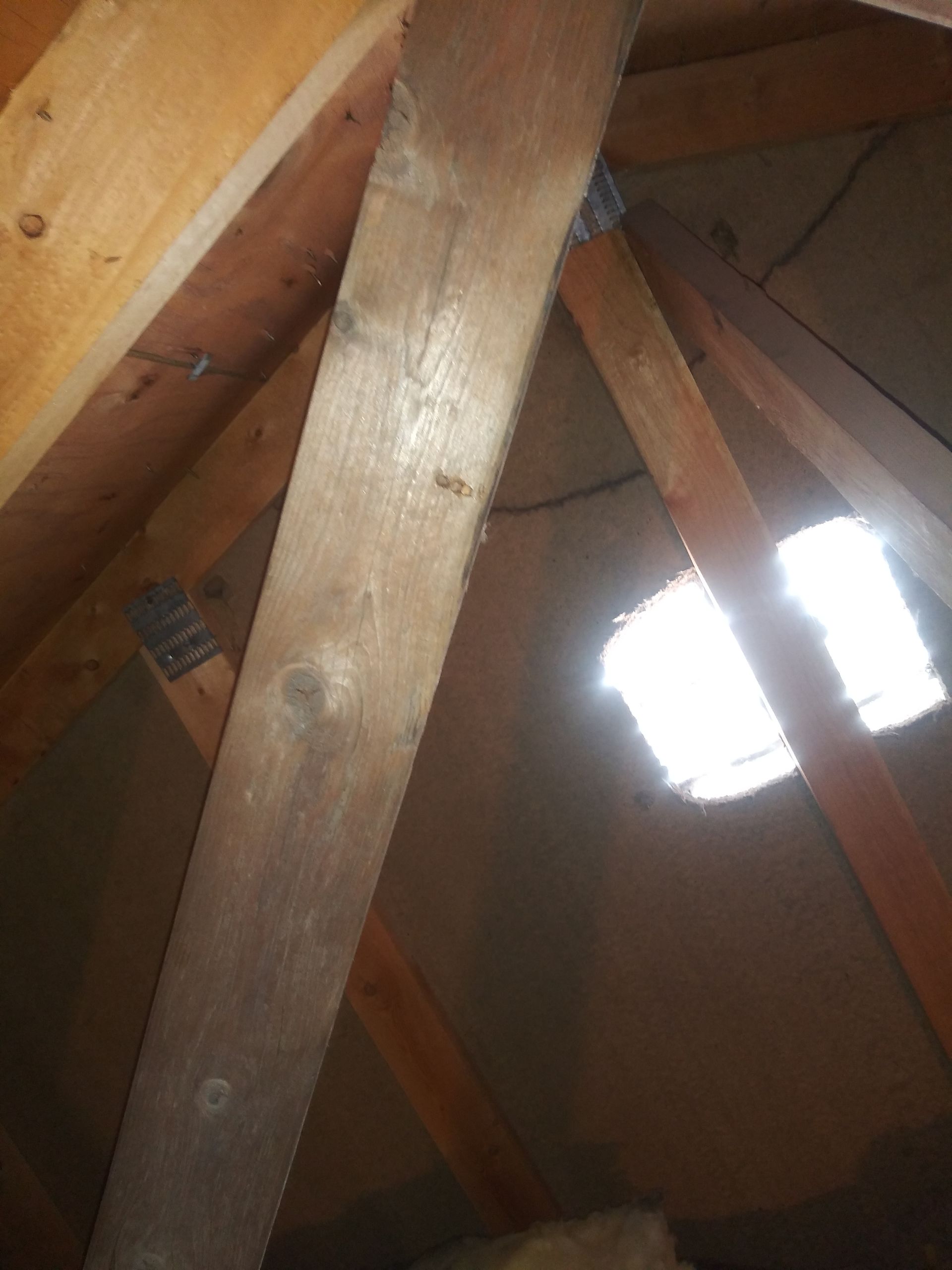 A close up of a wooden structure with a window in the ceiling.