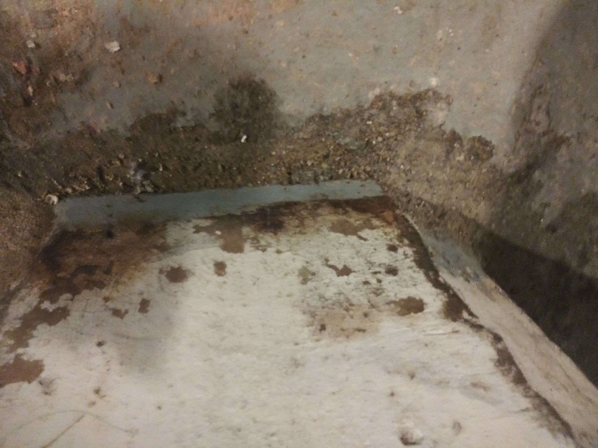 A close up of a dirty concrete floor with a hole in it.