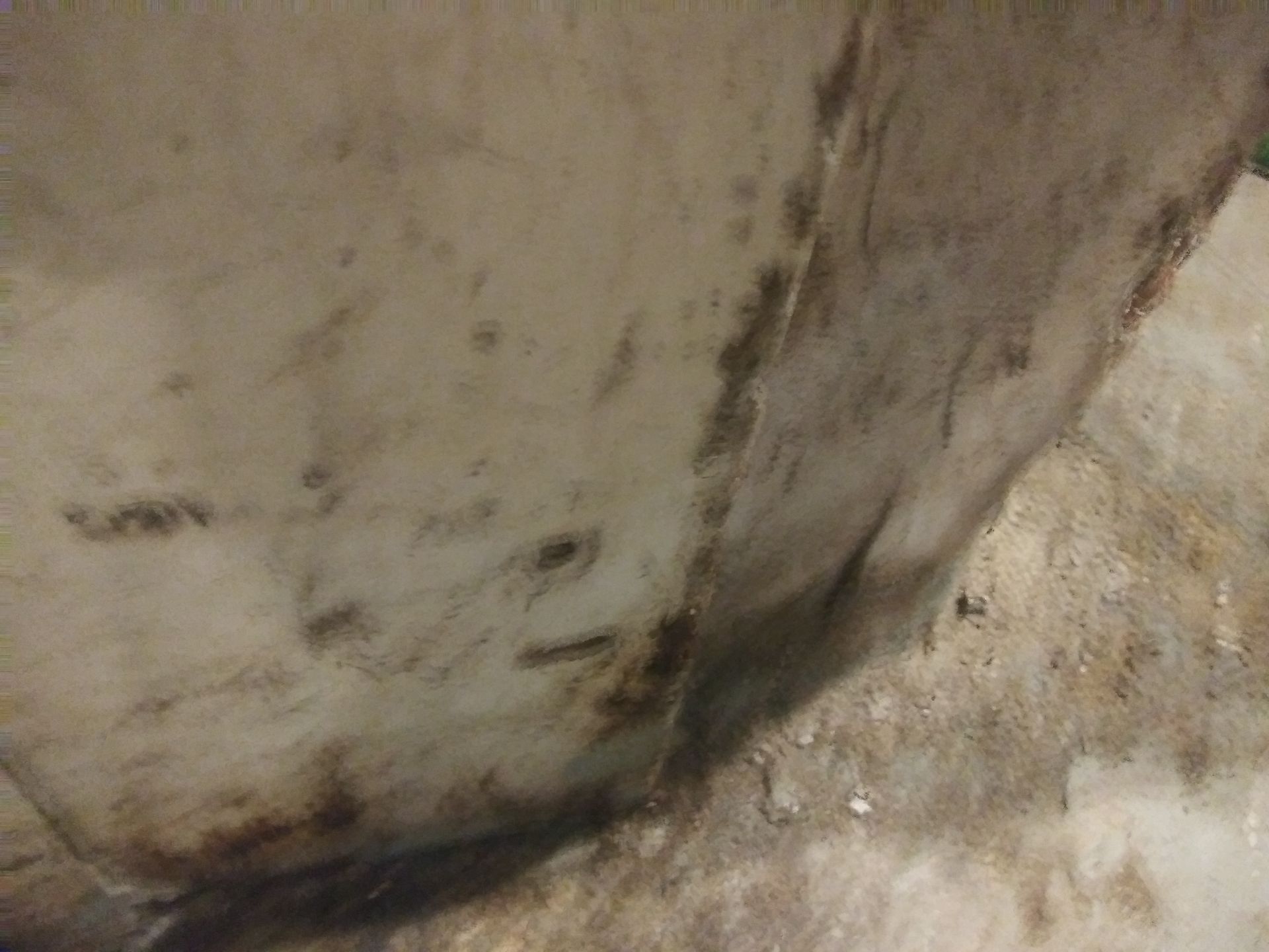 A close up of a dirty wall with a lot of stains on it.