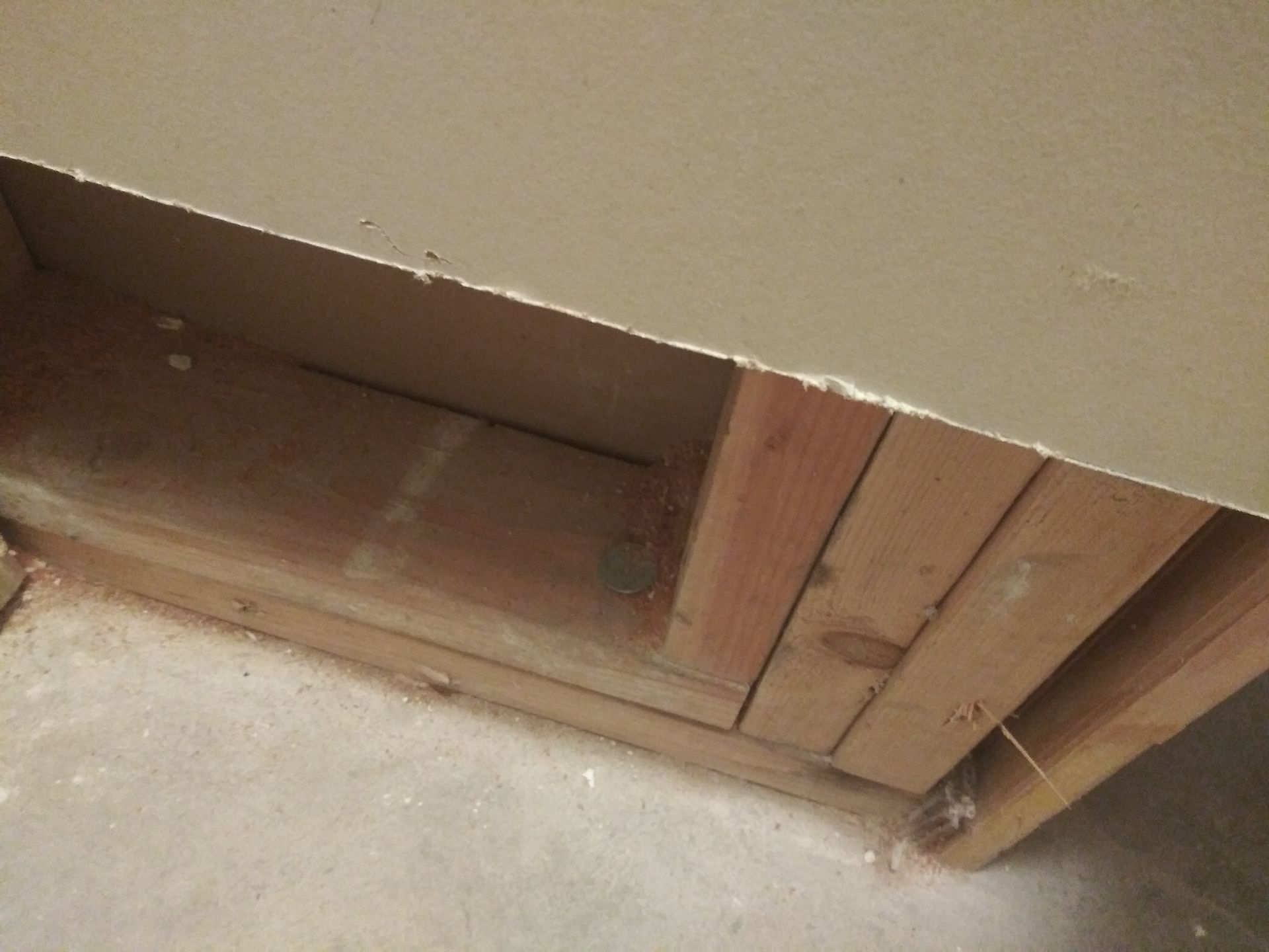 A piece of wood is sitting on the floor next to a wall.