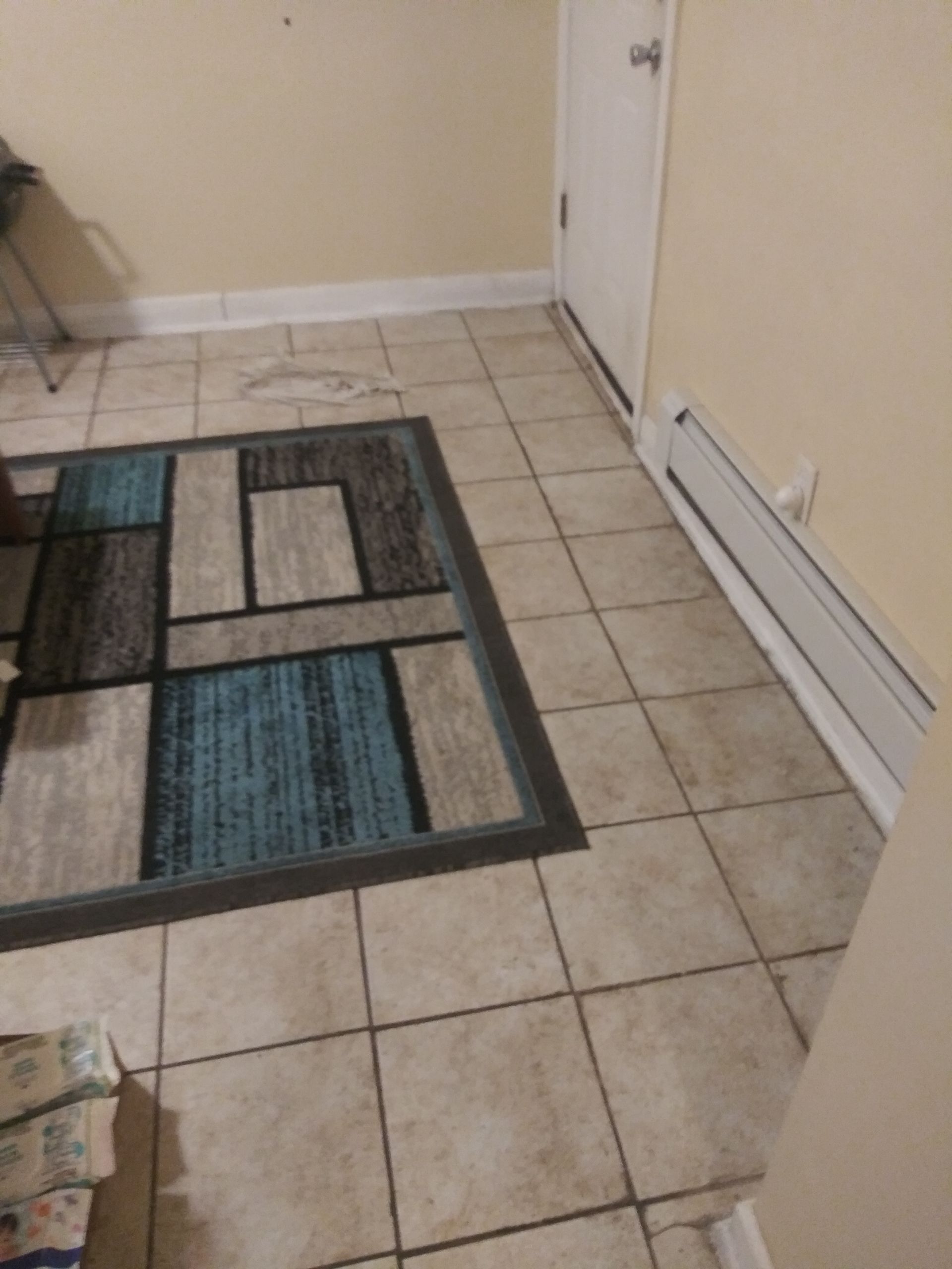 A room with tile floors and a rug on the floor