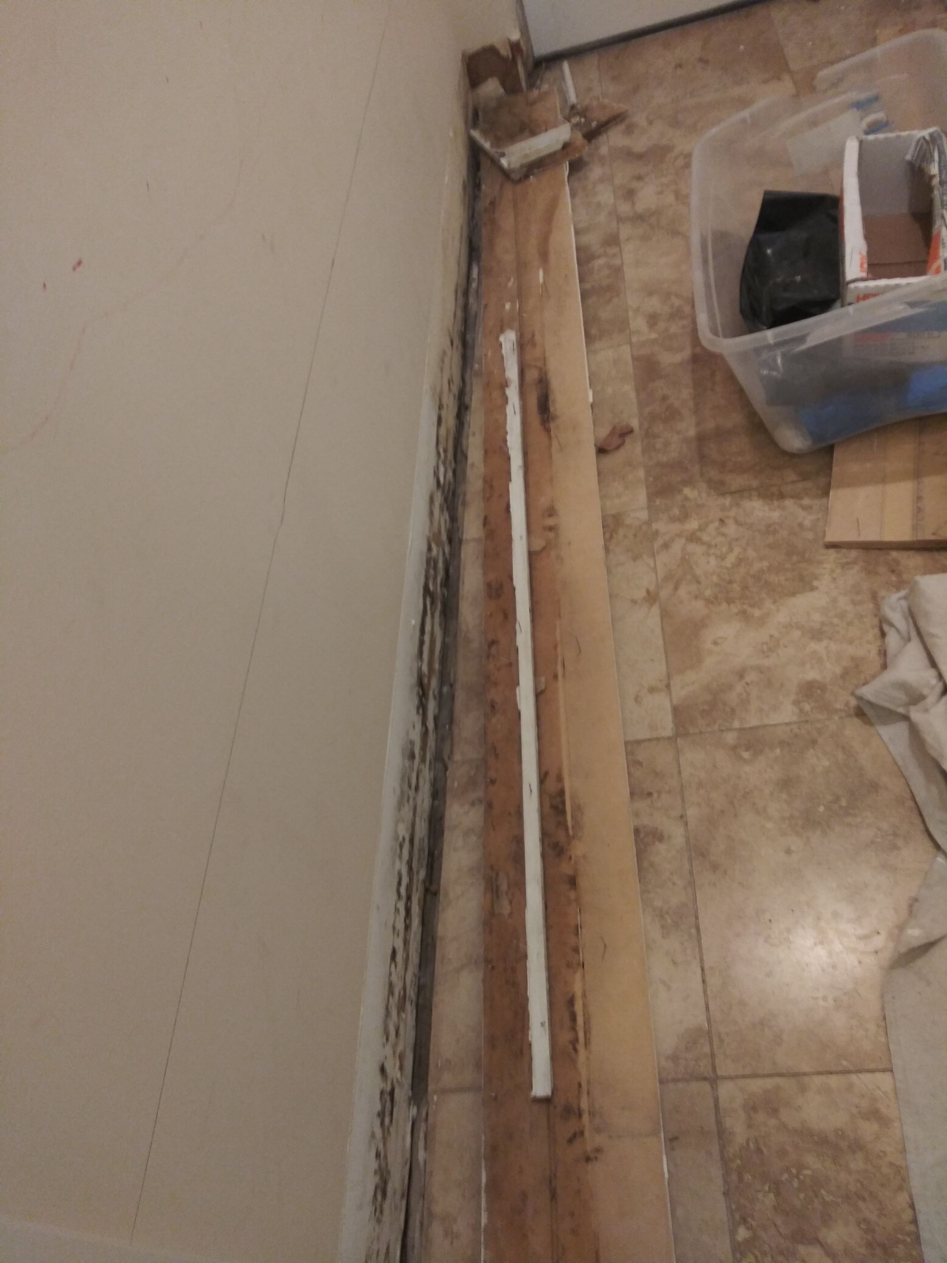 A piece of wood is sitting on the floor next to a wall.