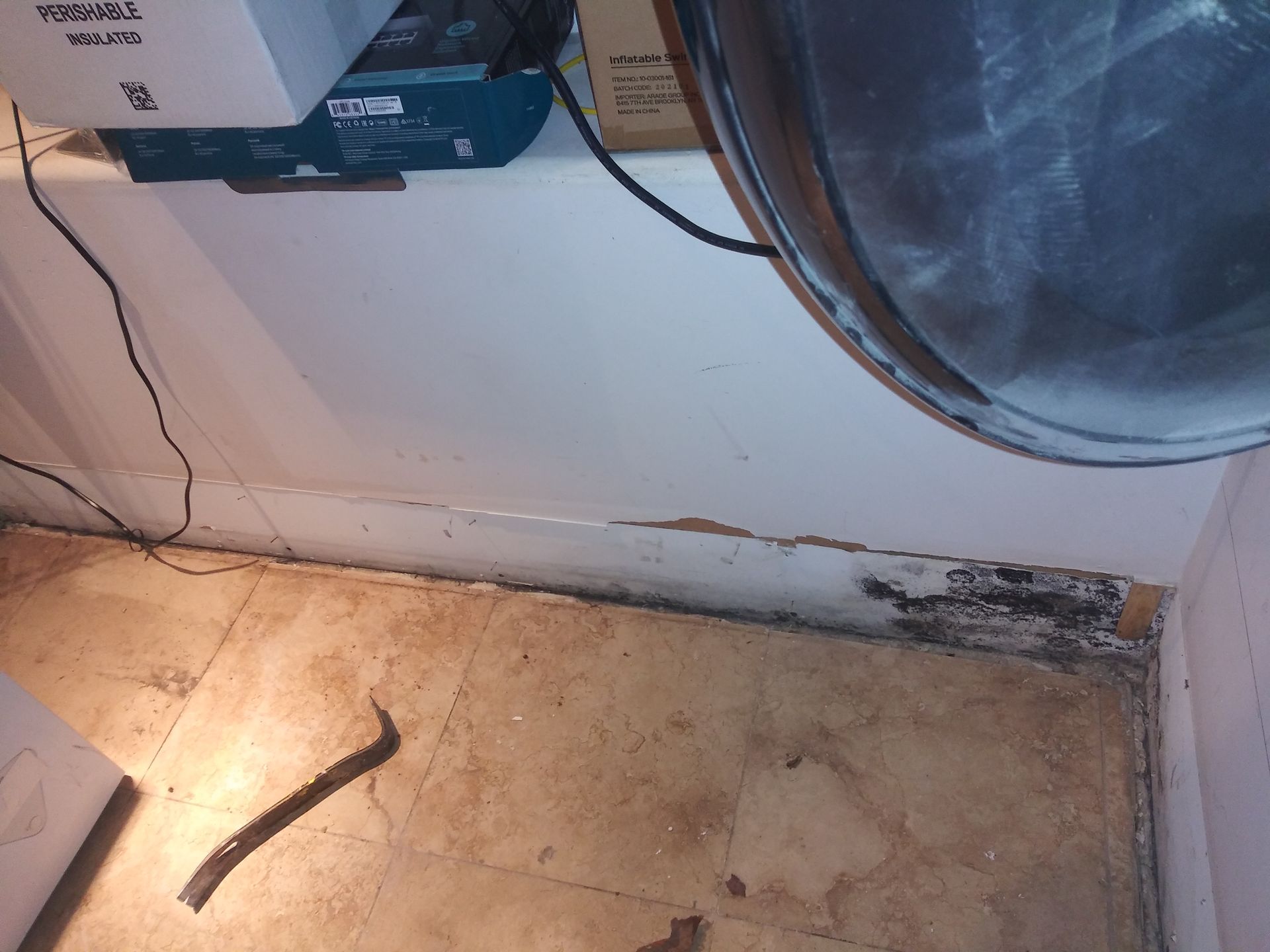 A hammer is laying on the floor next to a washer and dryer.