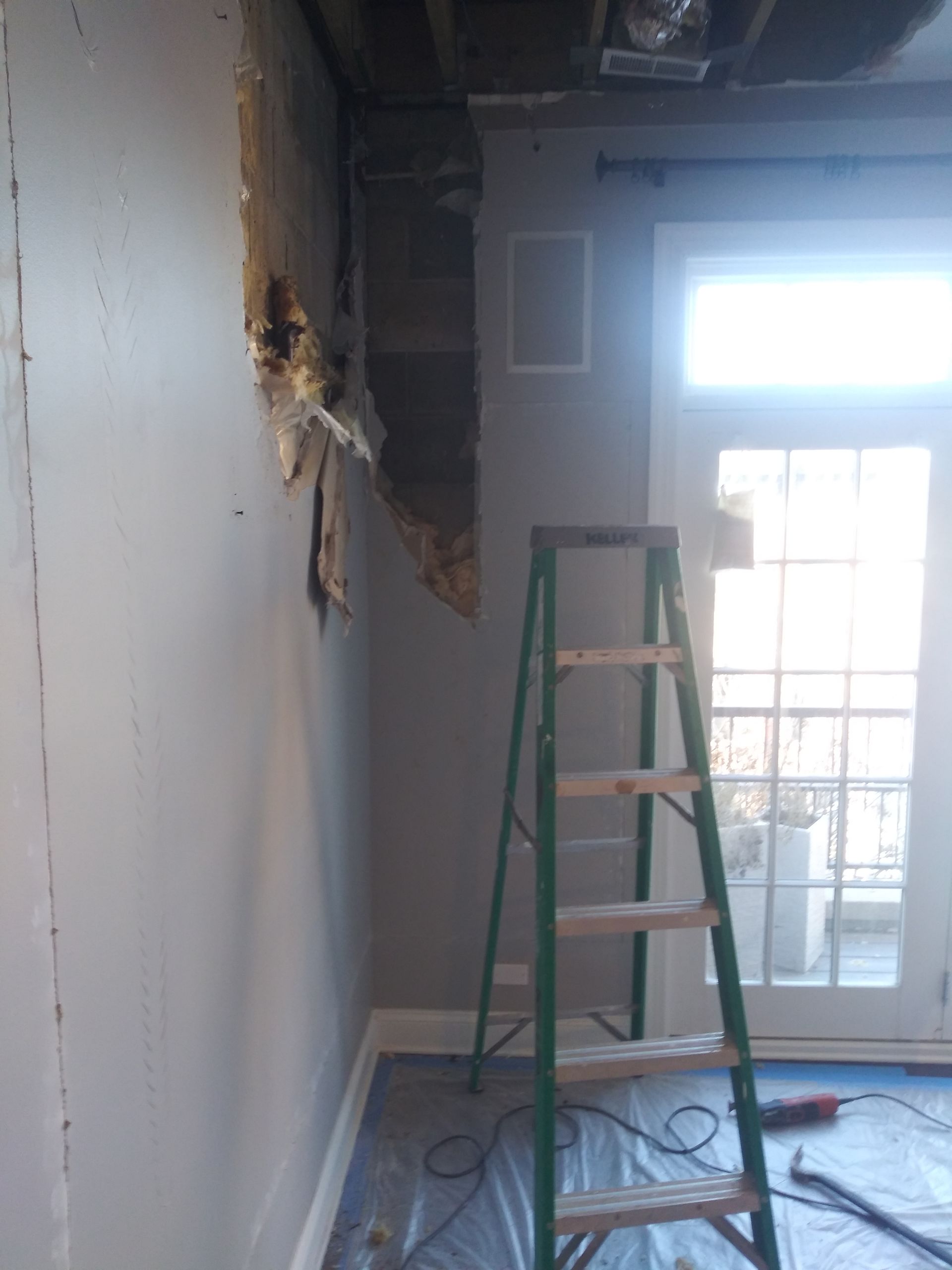 A room with a ladder and a hole in the wall
