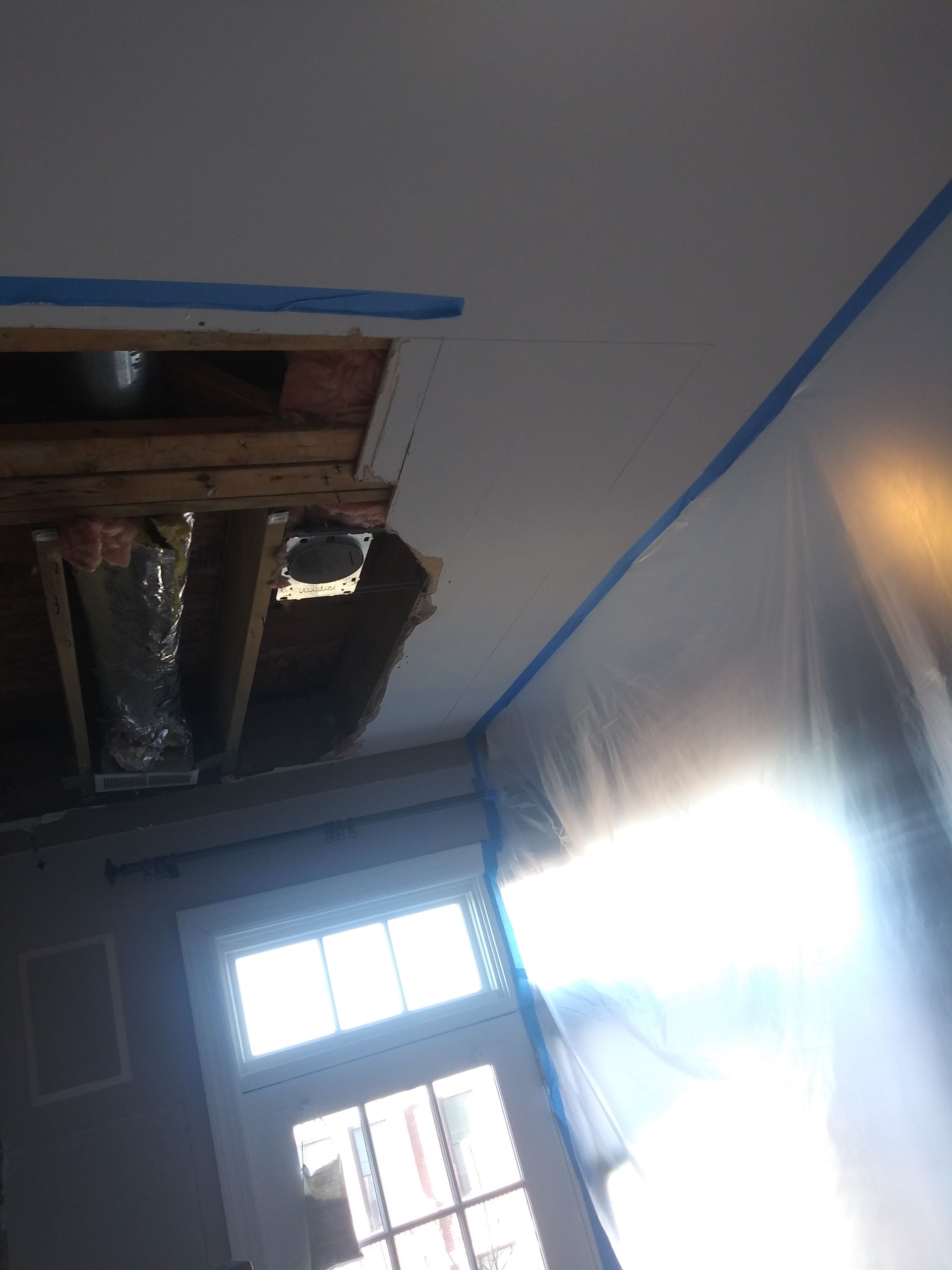 A room with a hole in the ceiling and a window