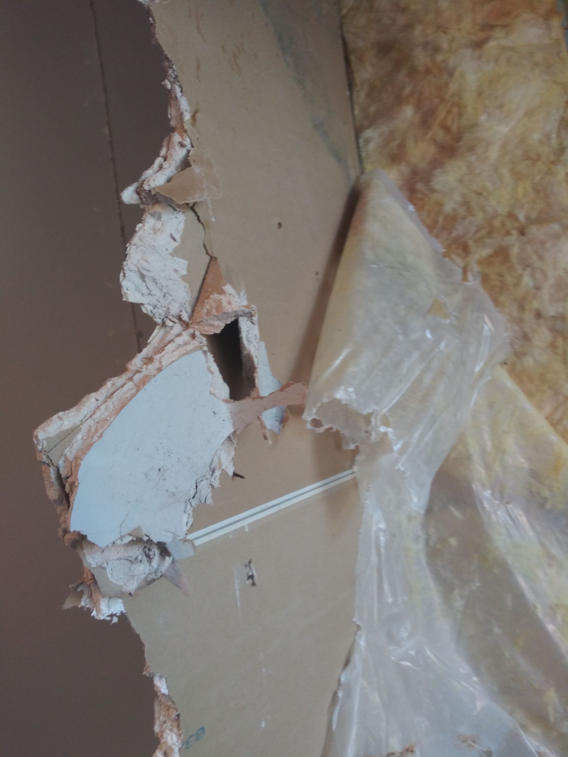 A close up of a broken wall with a hole in it