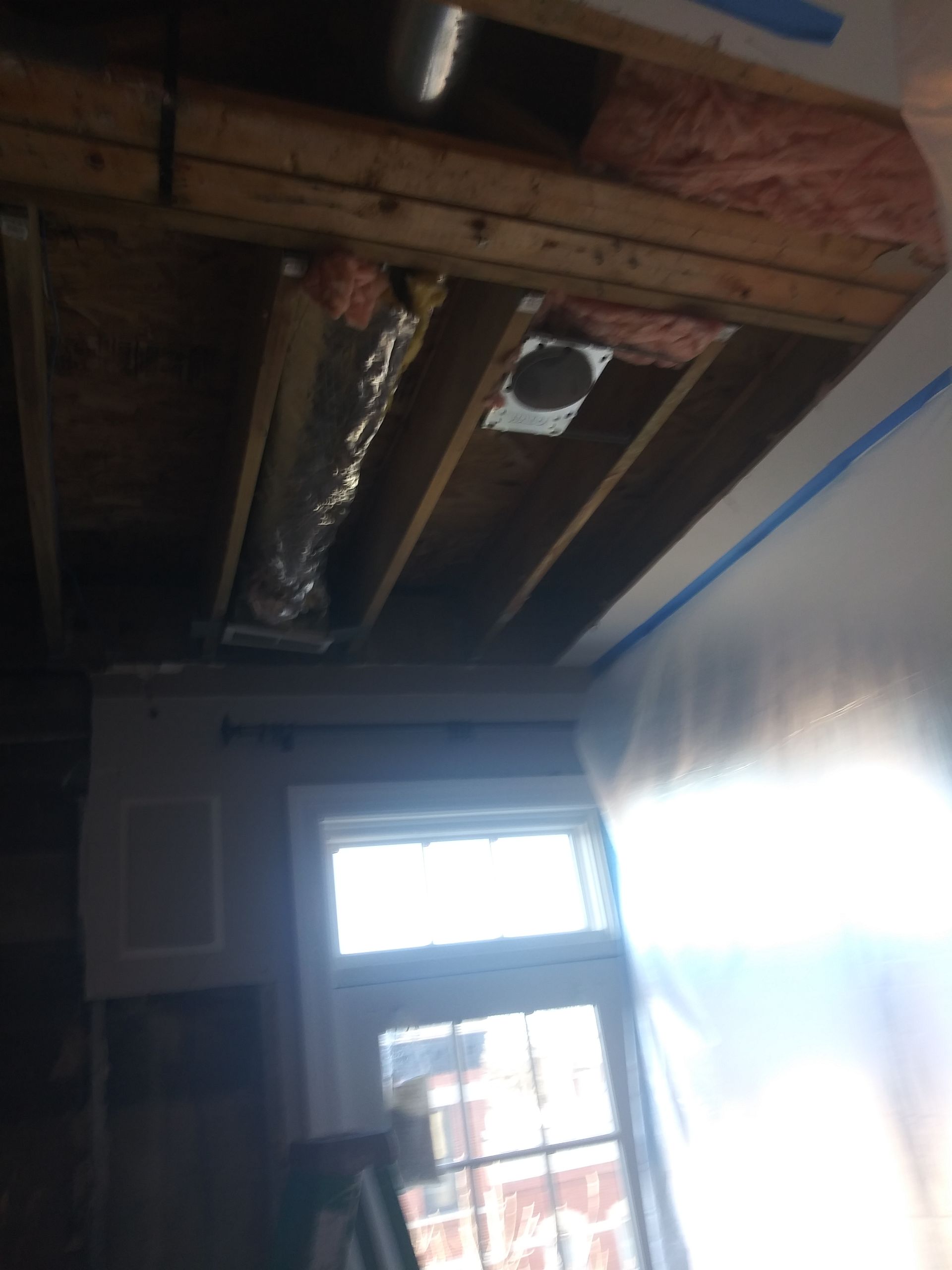 A room with a window and a wooden ceiling