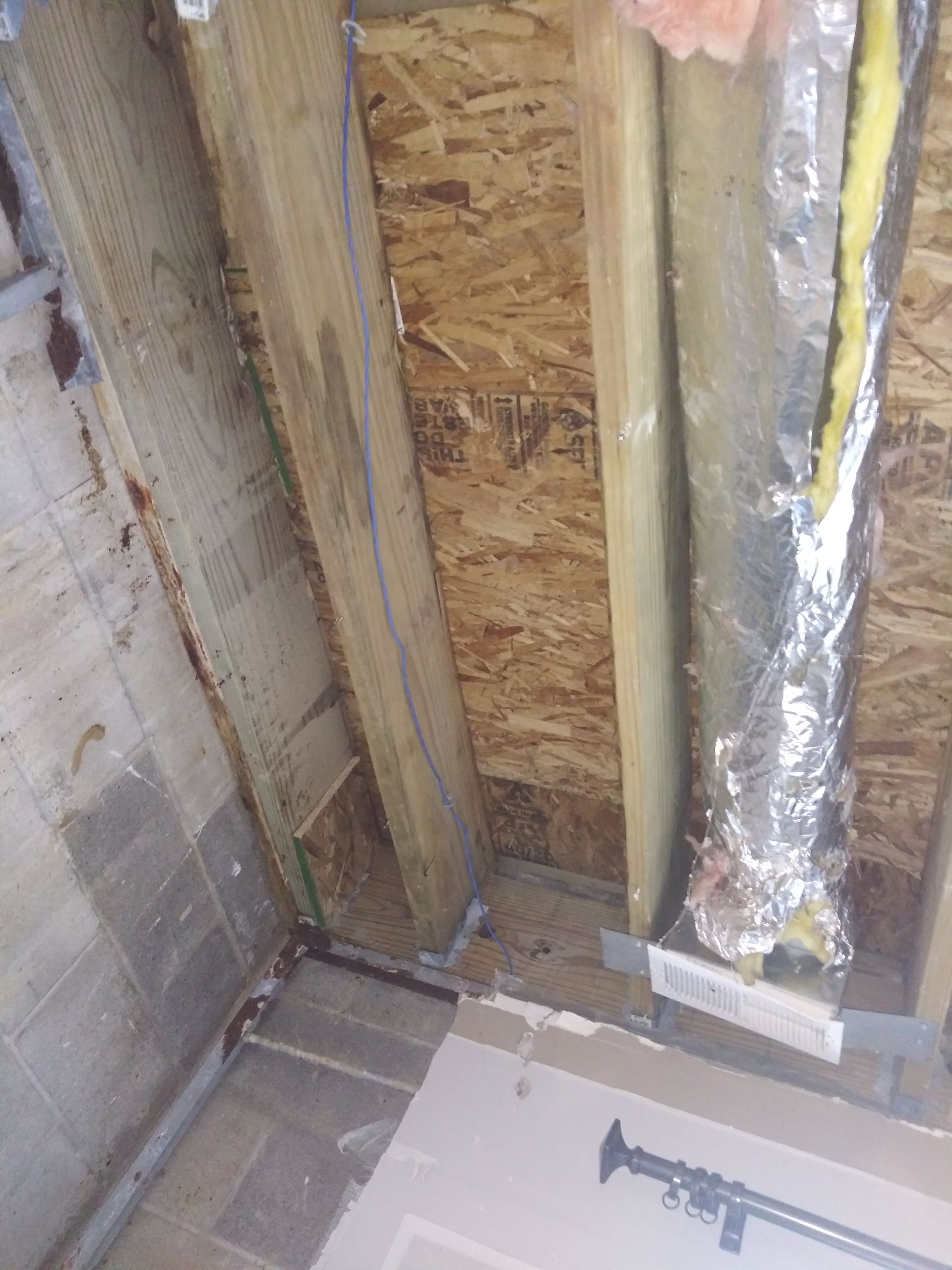 A room with a wooden ceiling and a metal pipe coming out of it.