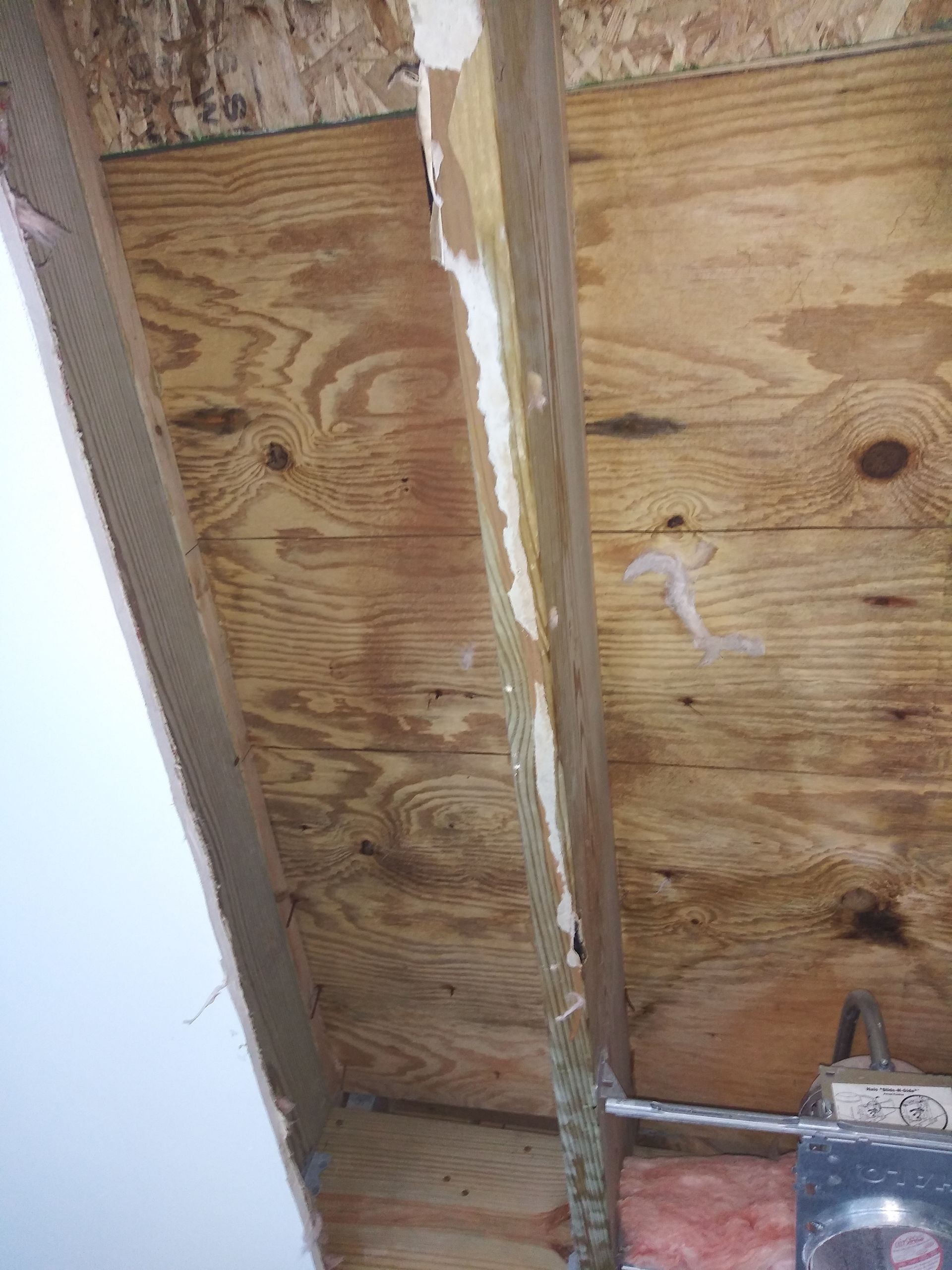 A close up of a wooden wall with a hole in it.