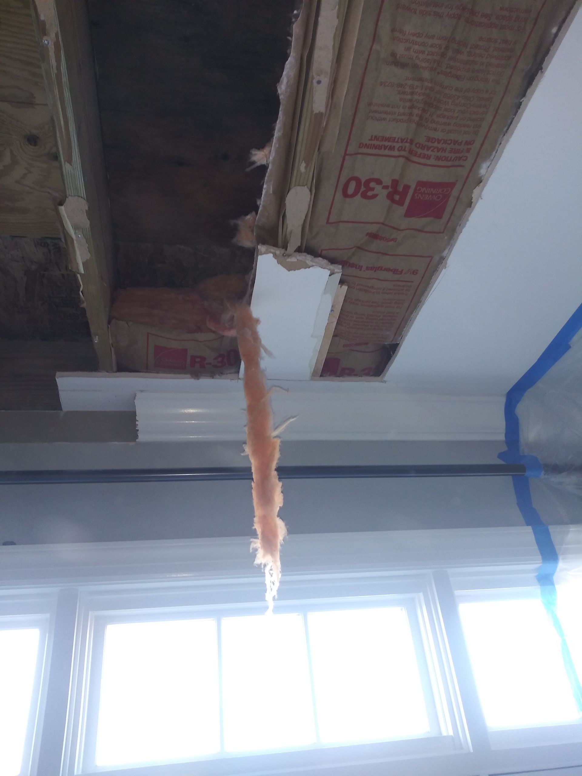 A cardboard box is hanging from the ceiling of a room.