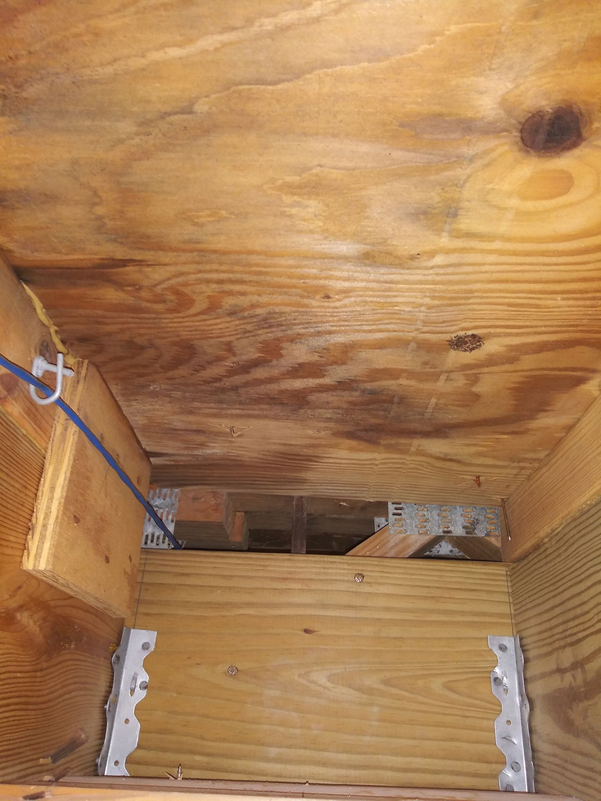 A wooden box with a blue wire coming out of it.