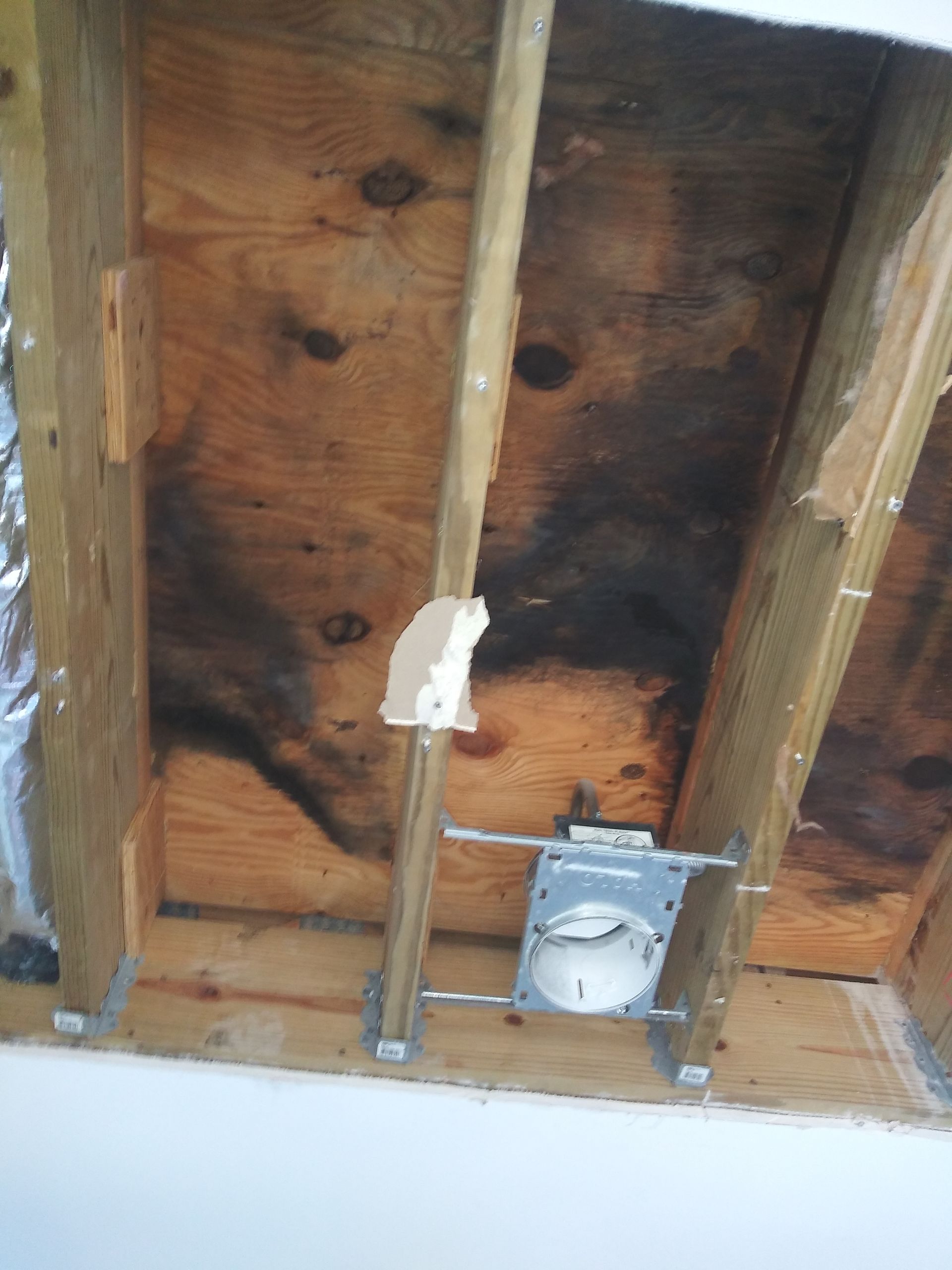 A wooden ceiling with a light fixture hanging from it.