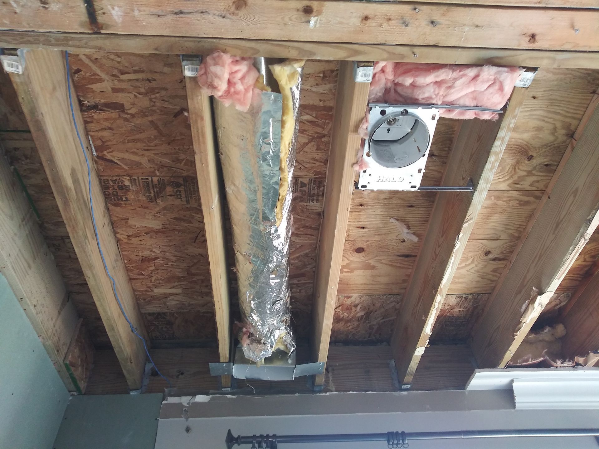 A wooden ceiling with a duct hanging from it.