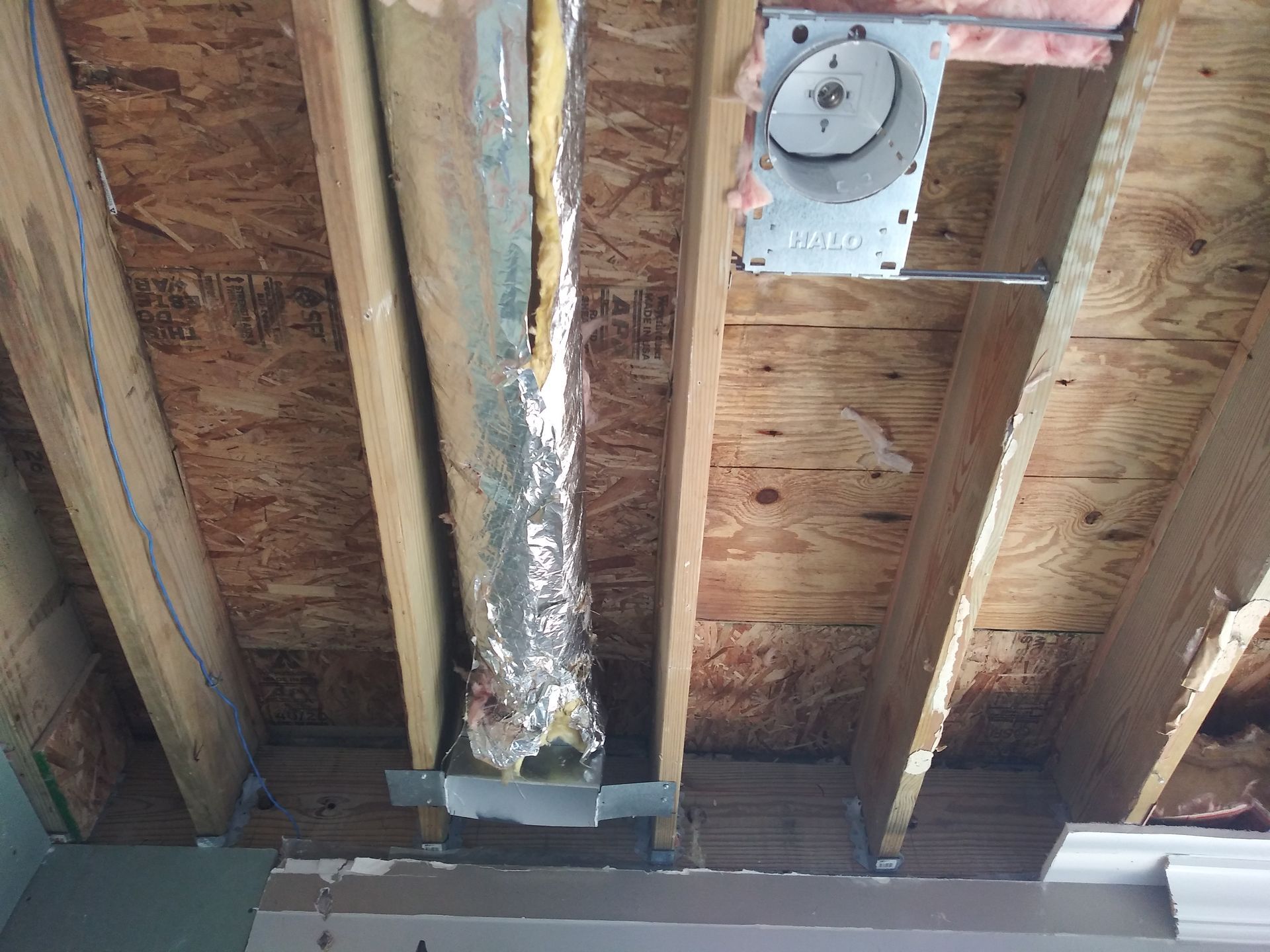A wooden ceiling with a metal pipe coming out of it.
