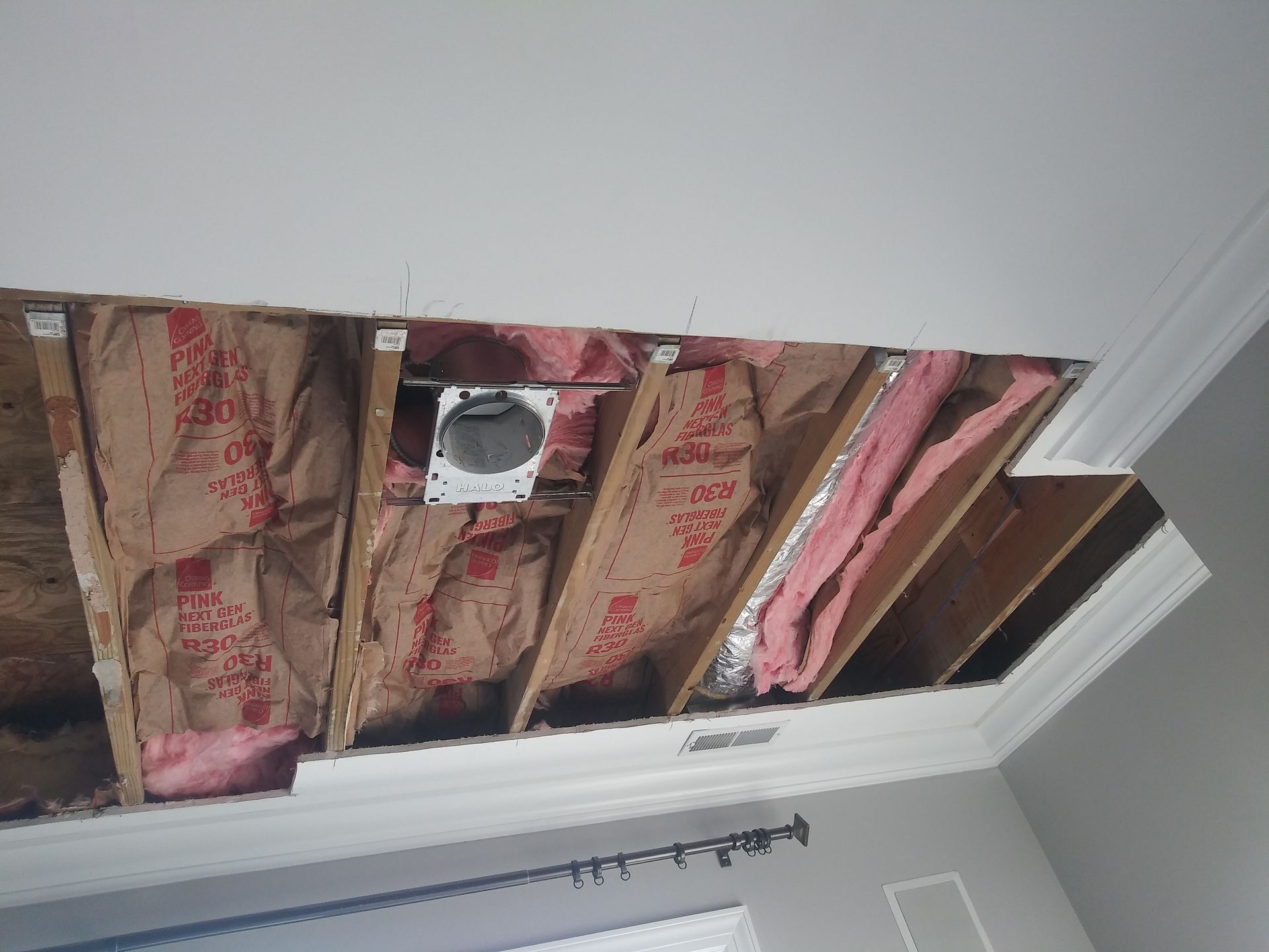A room with a hole in the ceiling and insulation.
