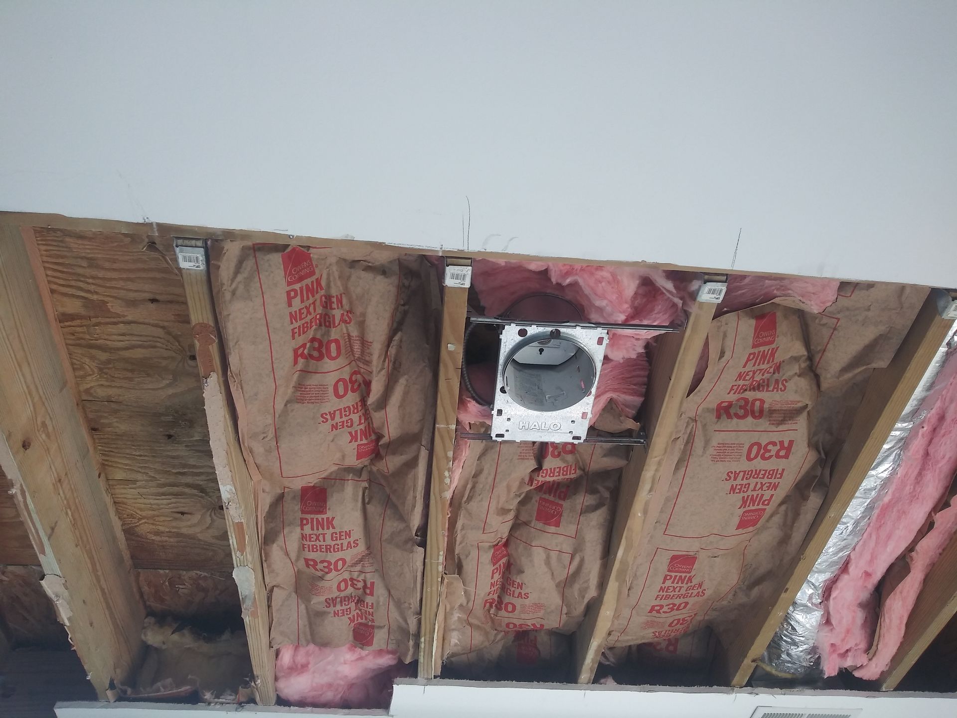 A picture of a ceiling with insulation and a fan.