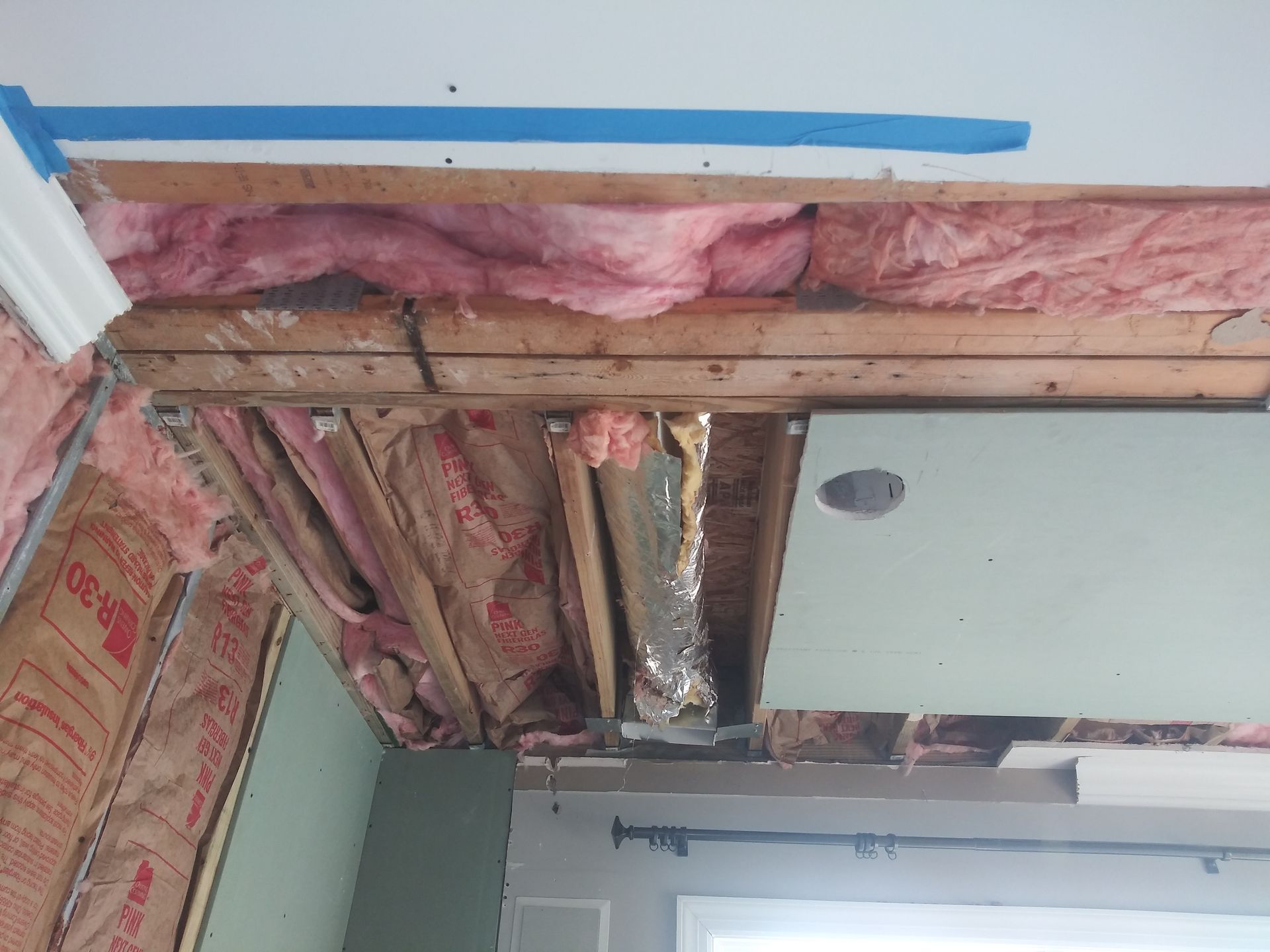 A room with a ceiling that is being remodeled with insulation.