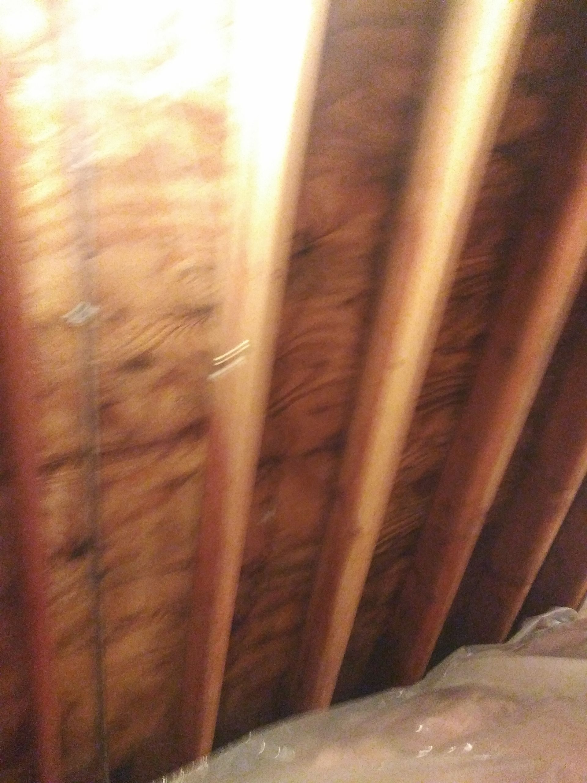 A close up of the ceiling of an attic with wooden beams.