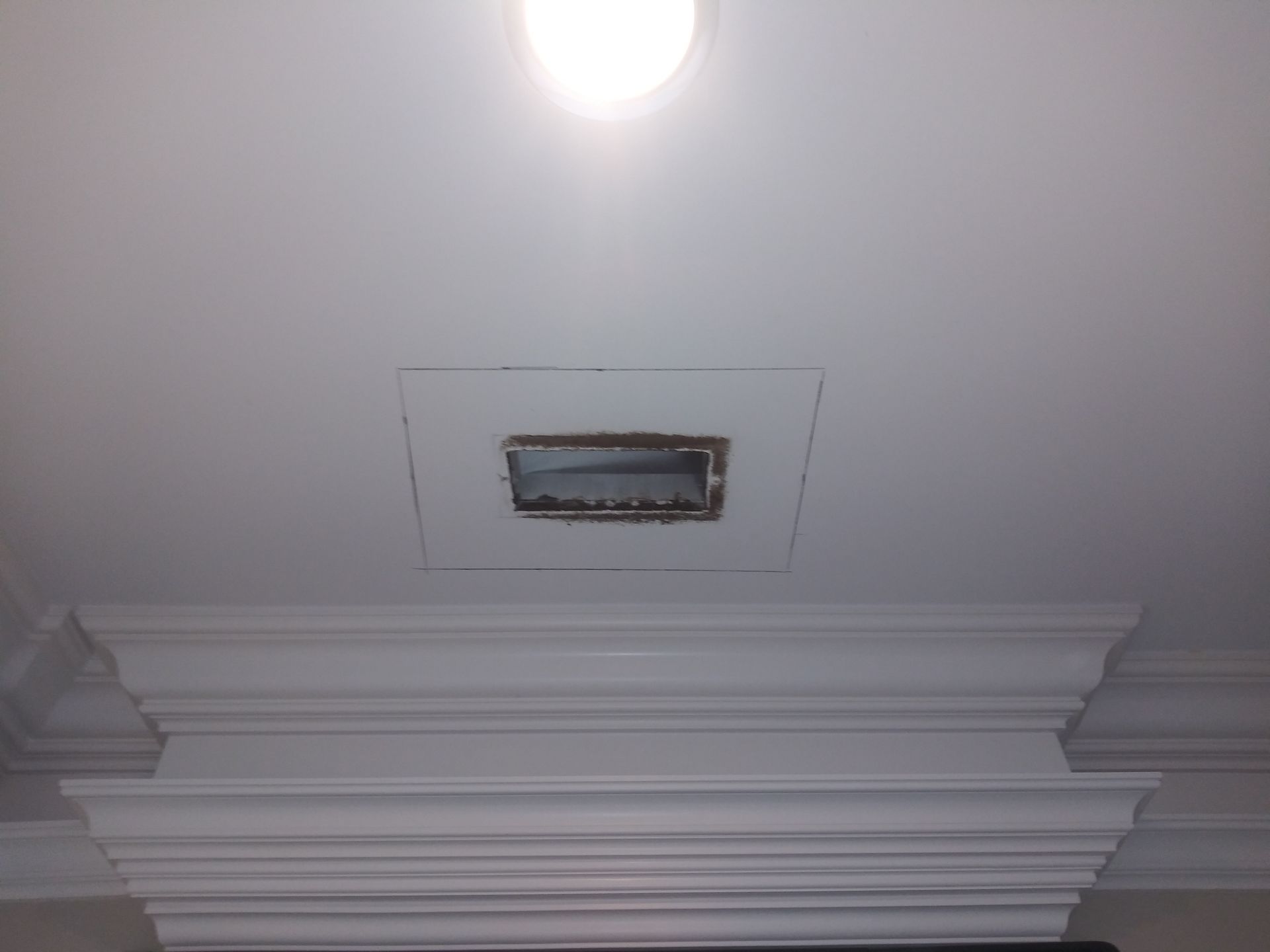 A white ceiling with a picture frame in the middle of it.