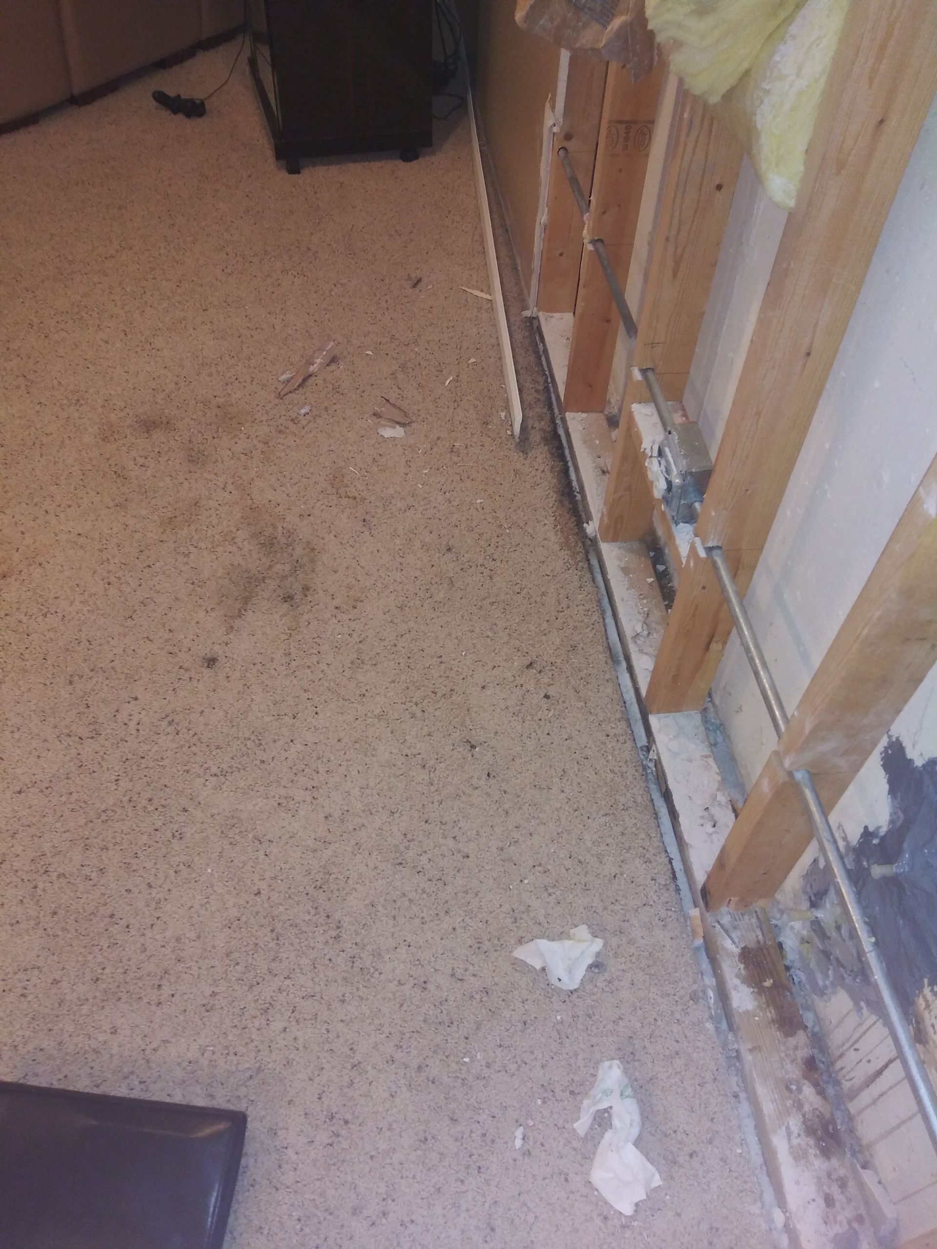 A room with a carpeted floor and a wooden wall