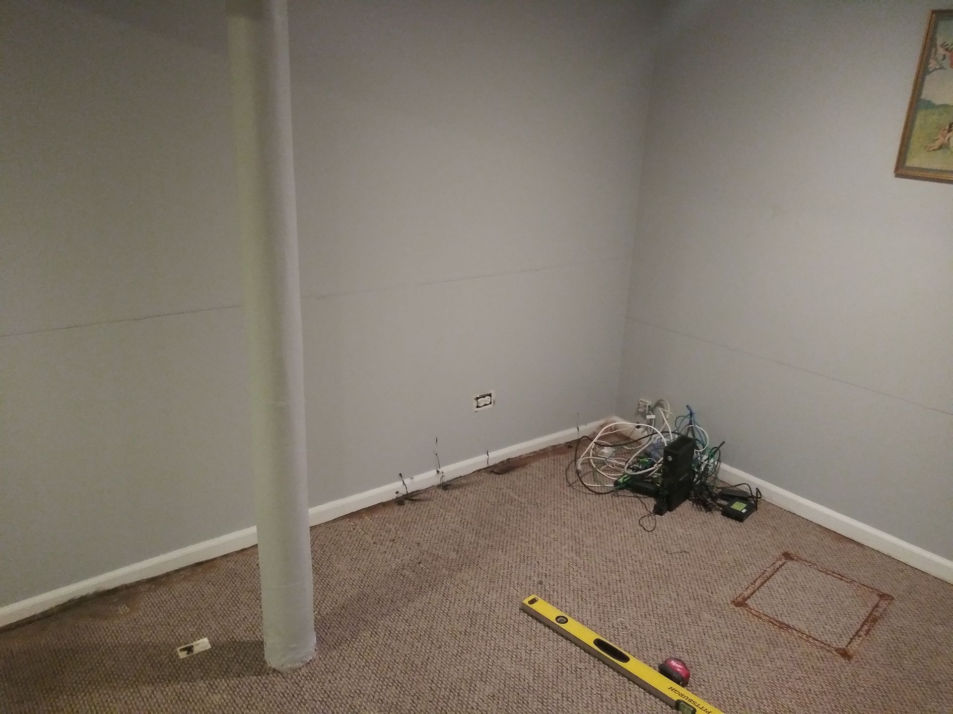 A room with a pole and a level on the floor.