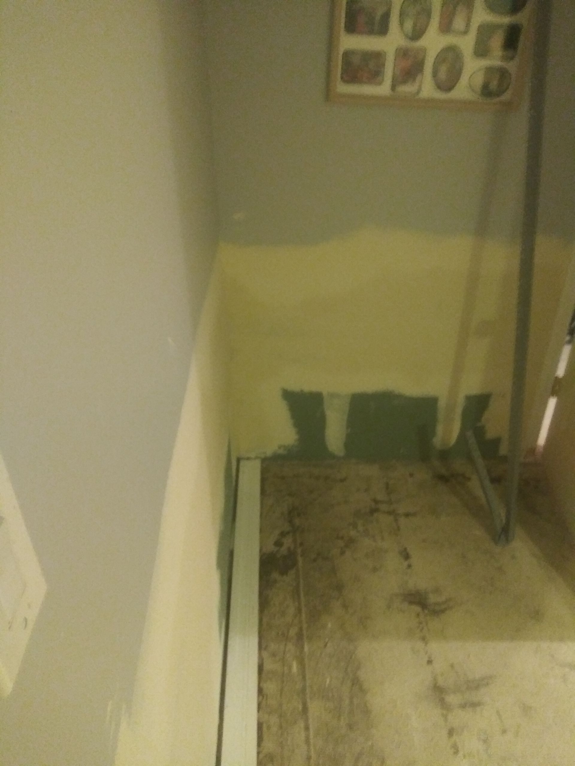 A room with a ladder and a picture on the wall.