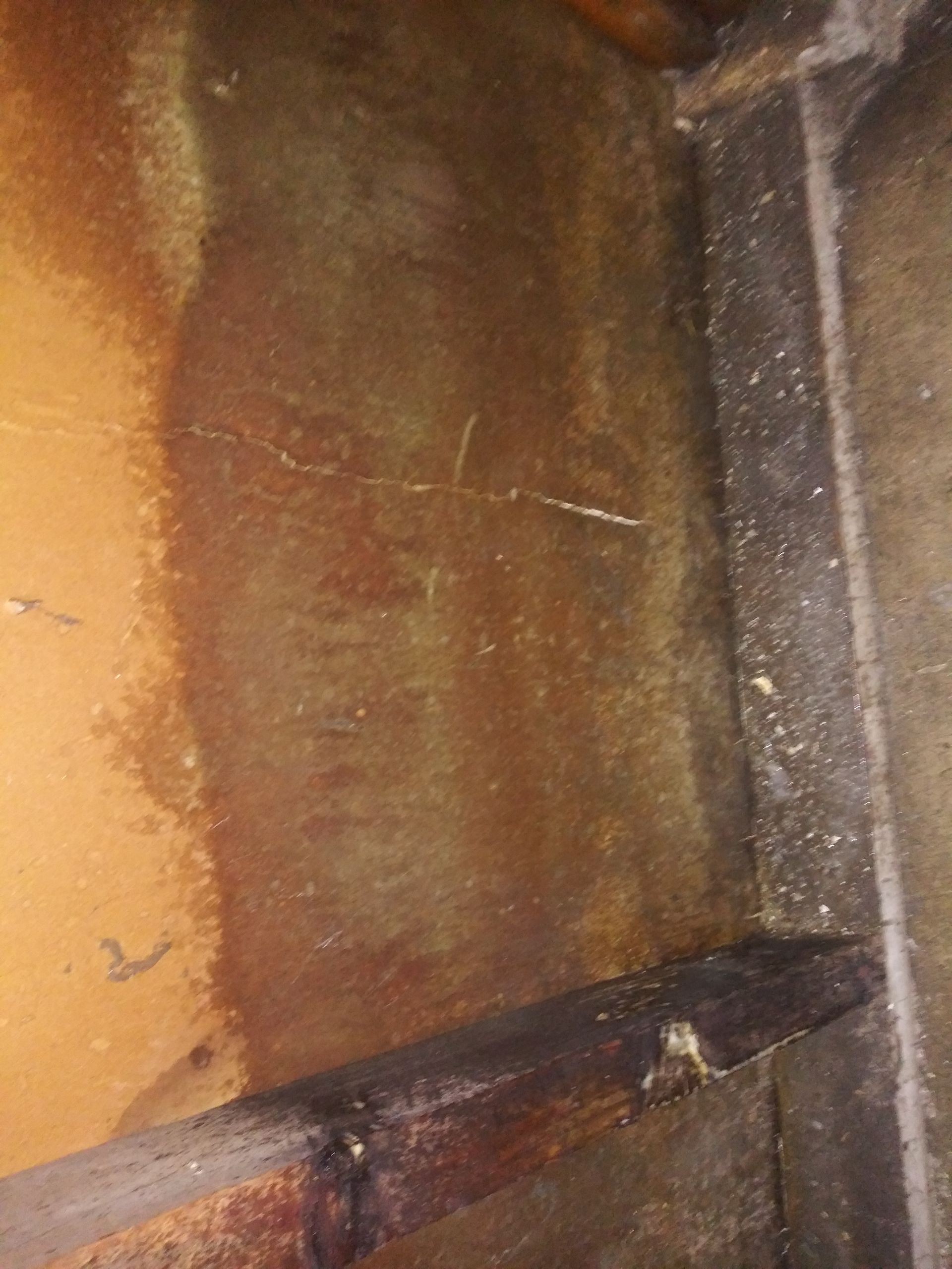 A close up of a rusty piece of metal on a wall.