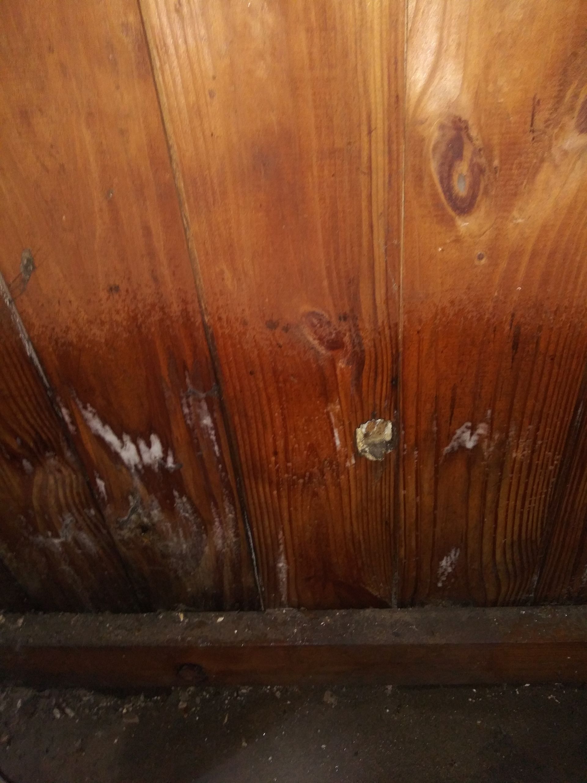 A close up of a wooden ceiling with a hole in it.