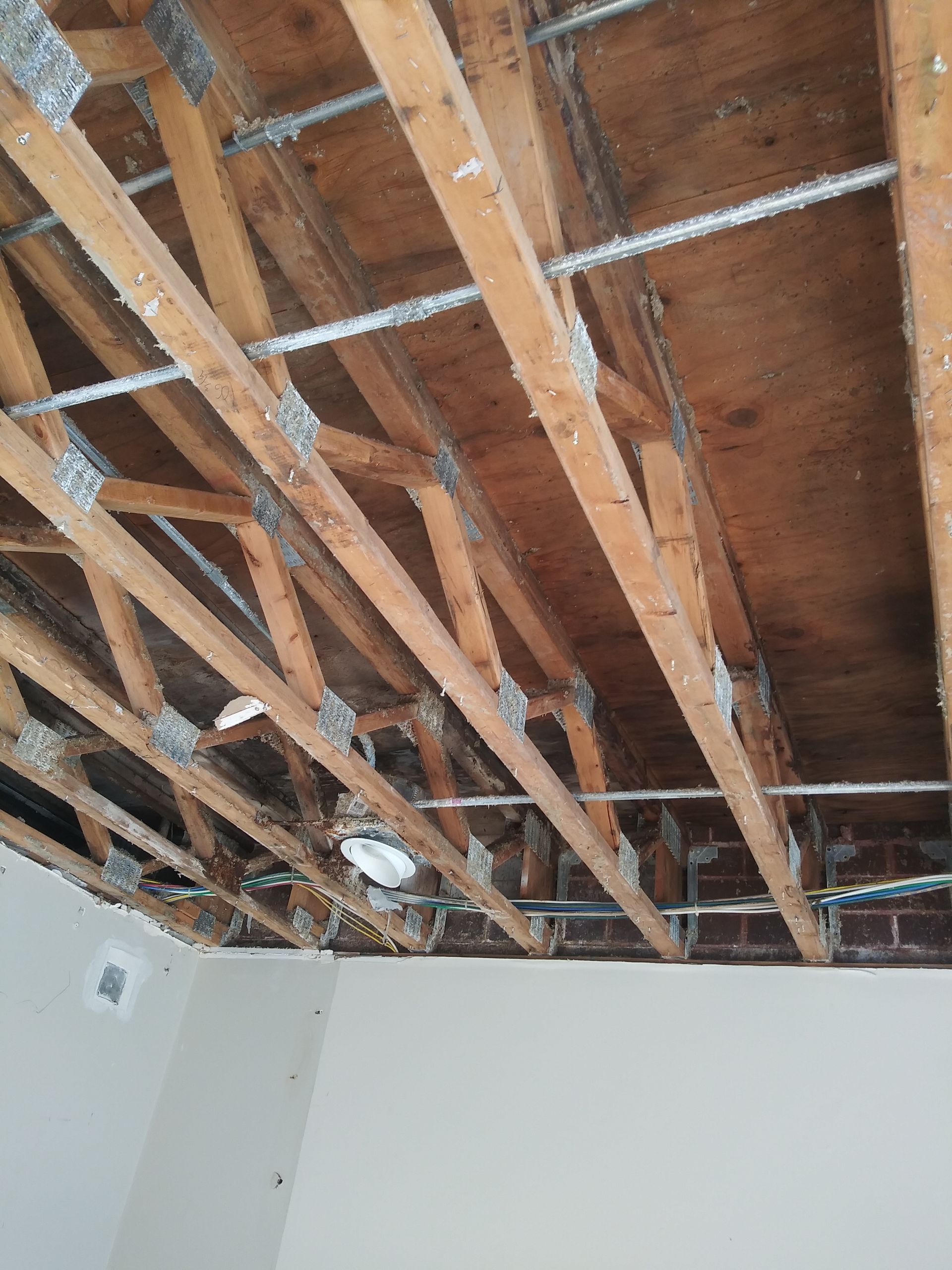 The ceiling of a room with wooden beams and a light.