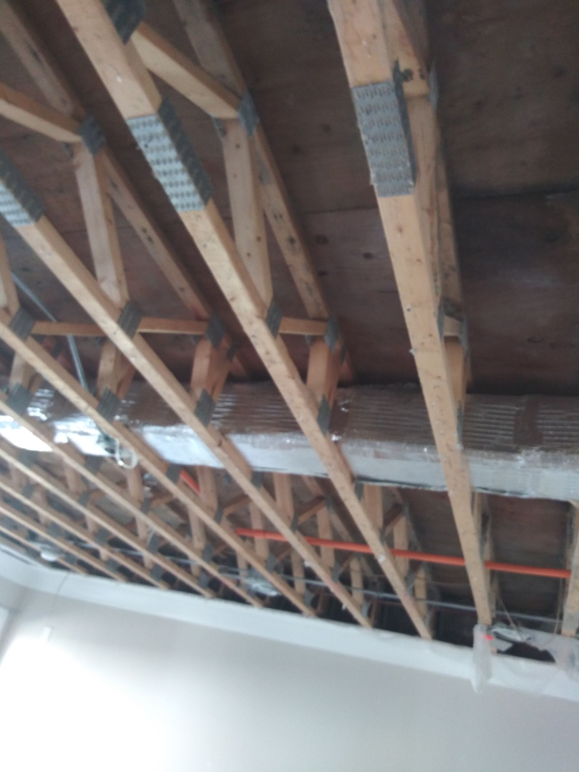 A ceiling with a lot of wooden beams and wires