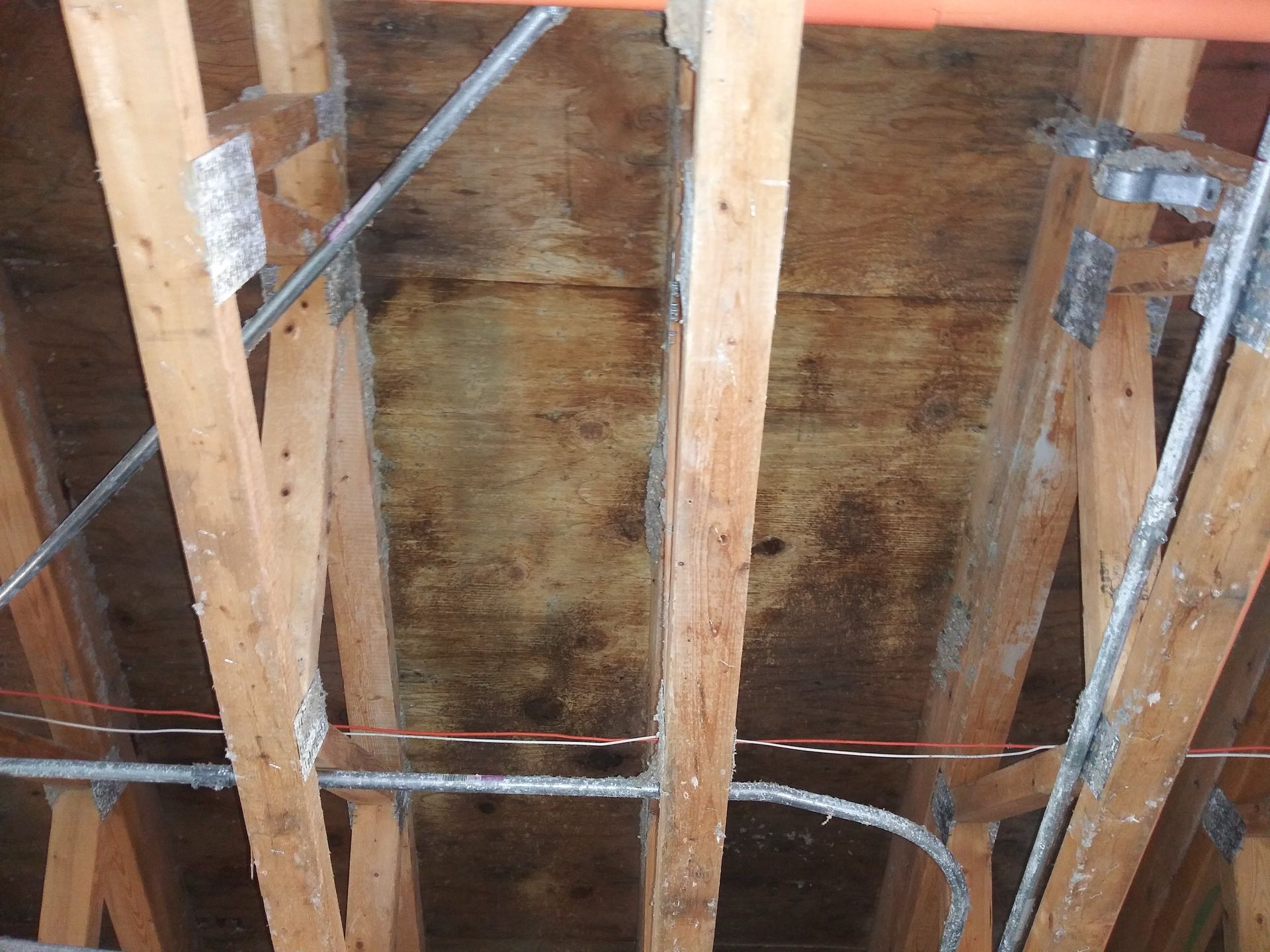 A ceiling with a lot of wooden beams and wires