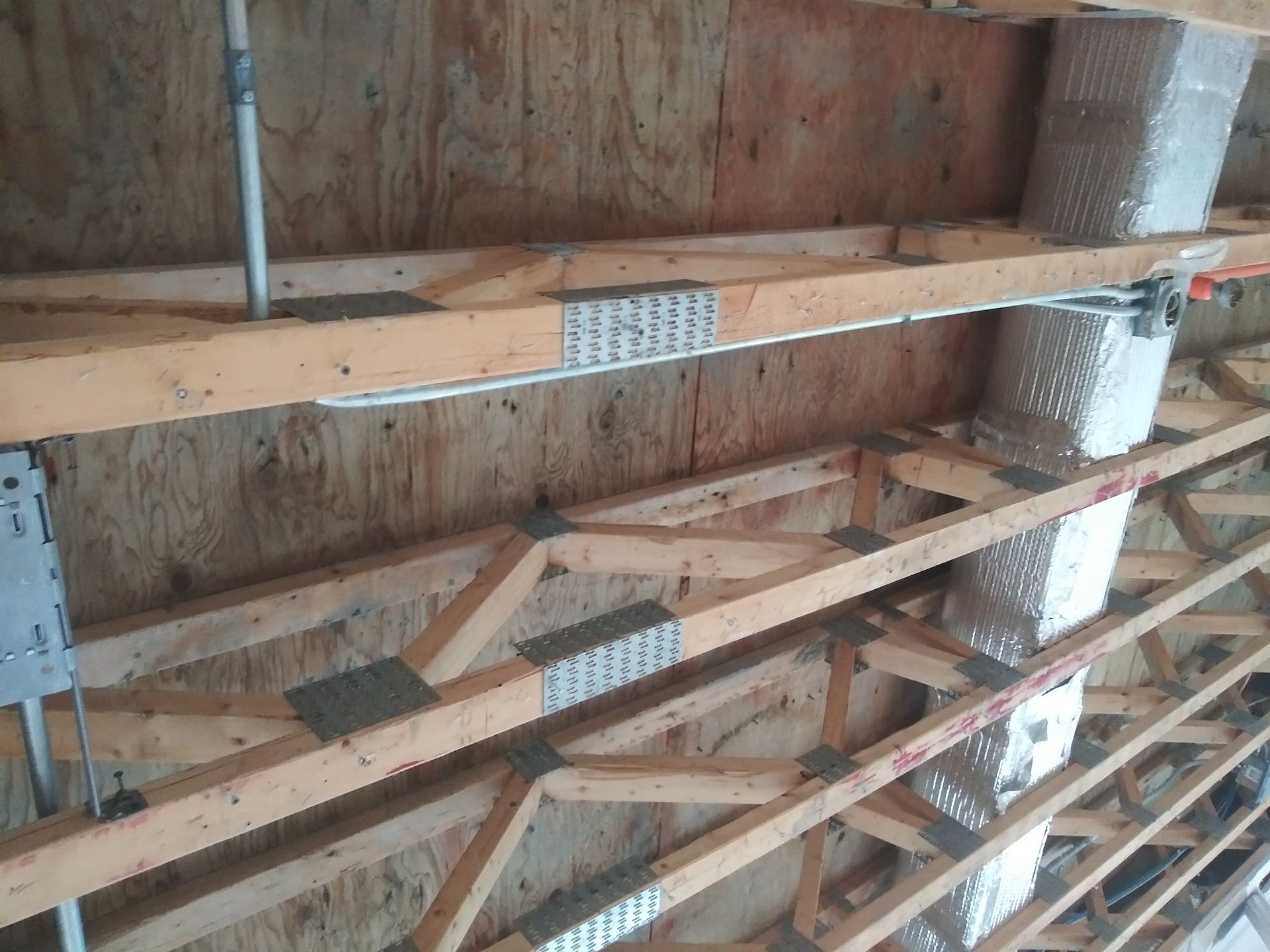 The ceiling of a building is being built with wooden beams.