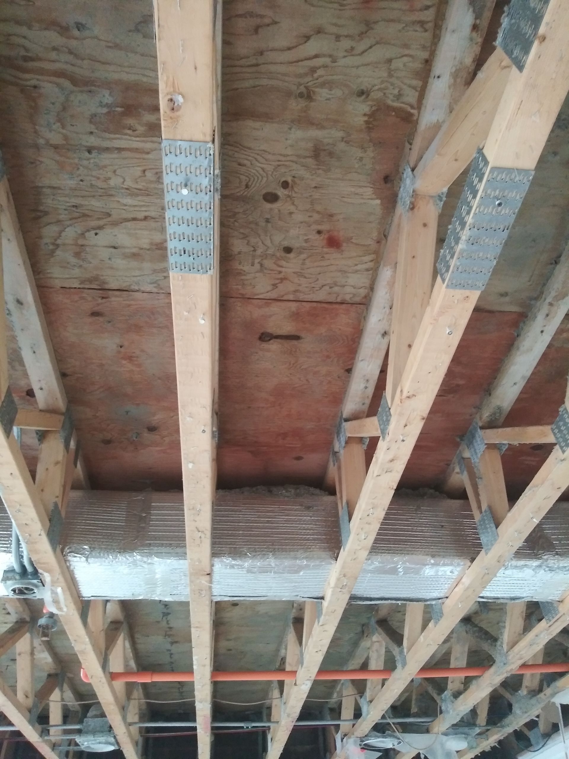 The ceiling of a house is being built with wooden beams.
